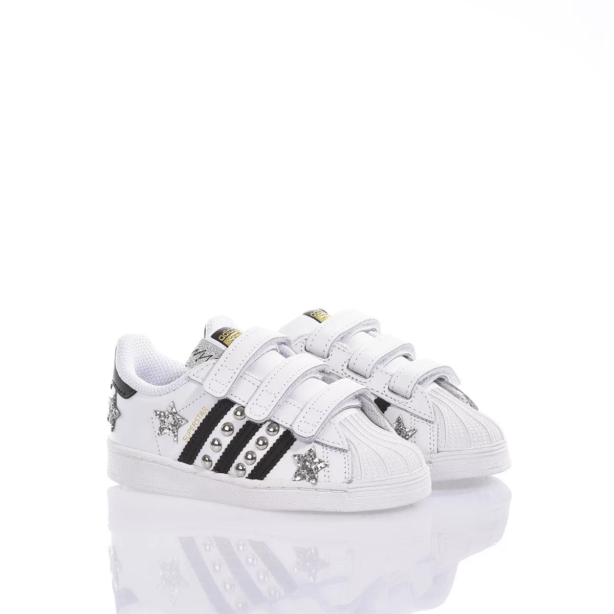 Scarpe bianche bambina con strisce nere, borchie e stelle glitterate, chiusura a strappo.