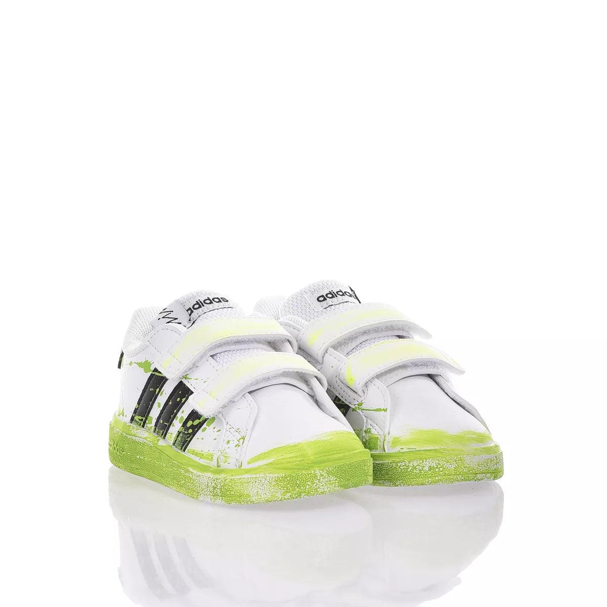Scarpe bianche con strisce nere e suola verde fluo, ideali per look premaman sportivi
