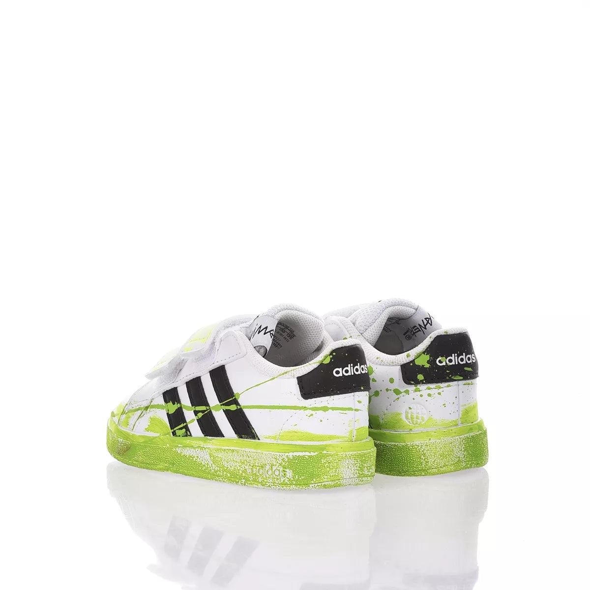 Scarpe da ginnastica bianche e verdi con dettagli neri, fondo riflettente. Non abbigliamento premaman.