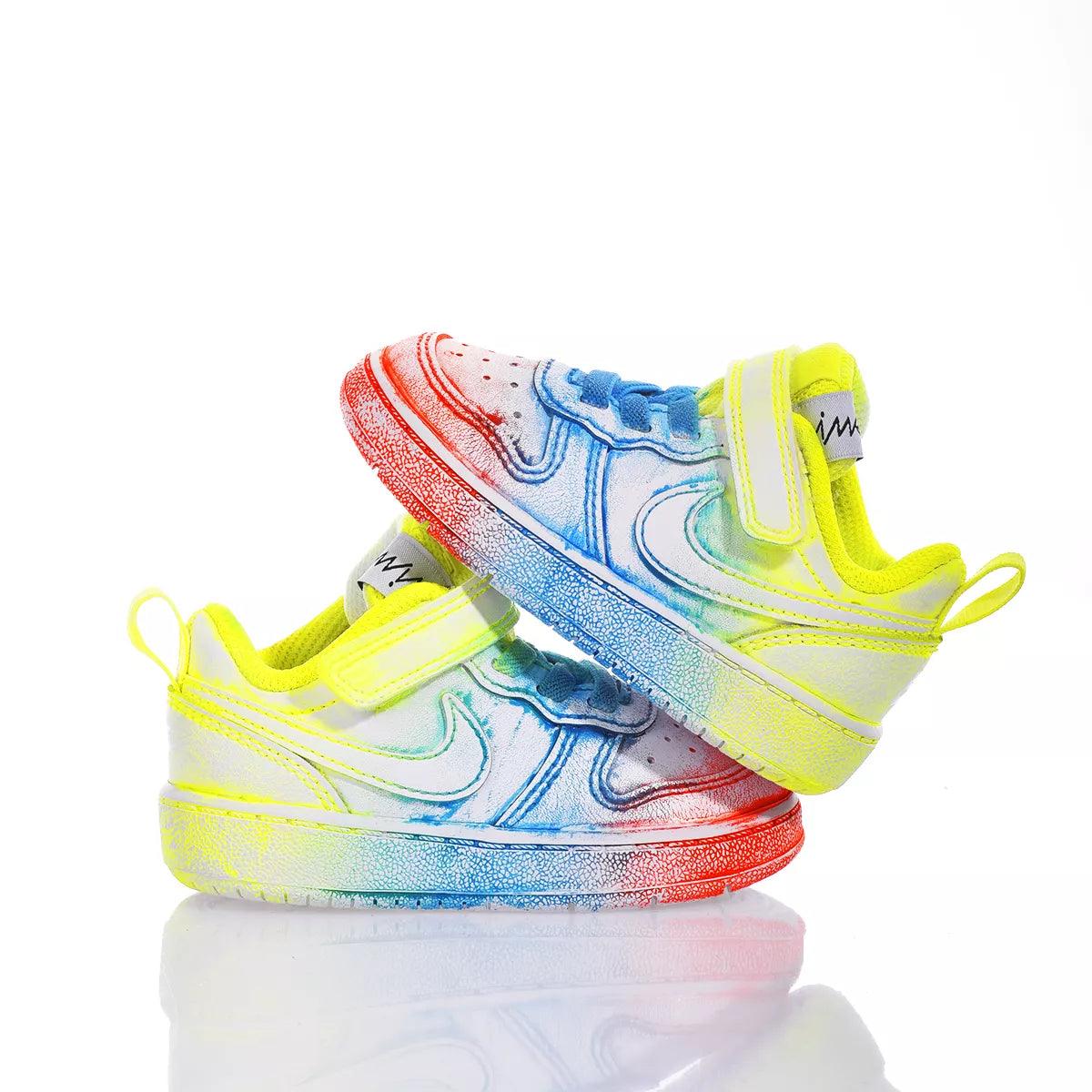 Scarpe da bambino colorate con chiusura a strappo, dettagli arcobaleno su sfondo bianco