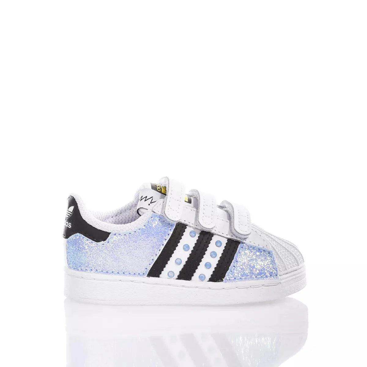 Scarpa da bambino bianca con dettagli glitter, adatta a look premaman casual e comodi.