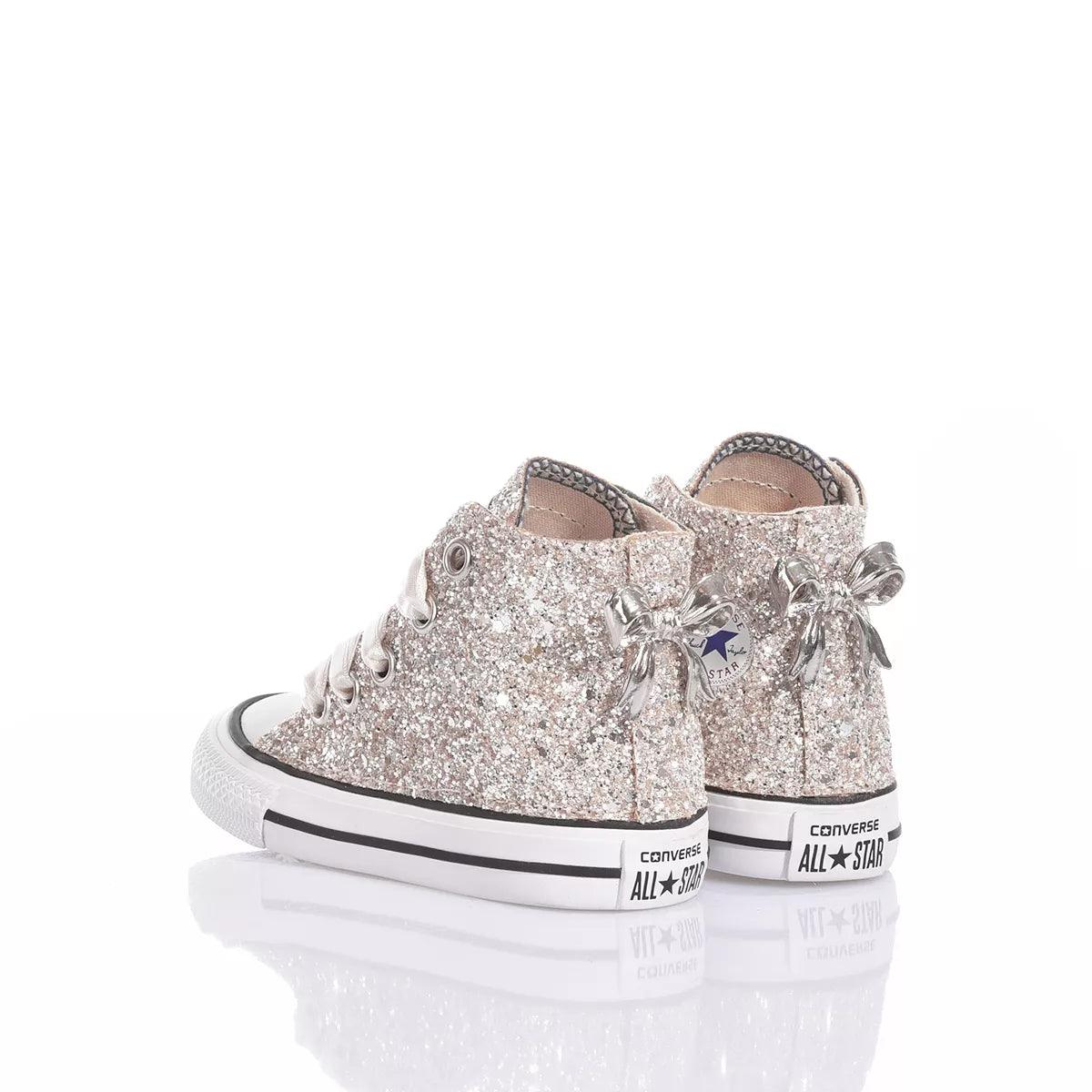 Sneakers glitterate argento con fiocchi, ideali per abbigliamento premaman alla moda.