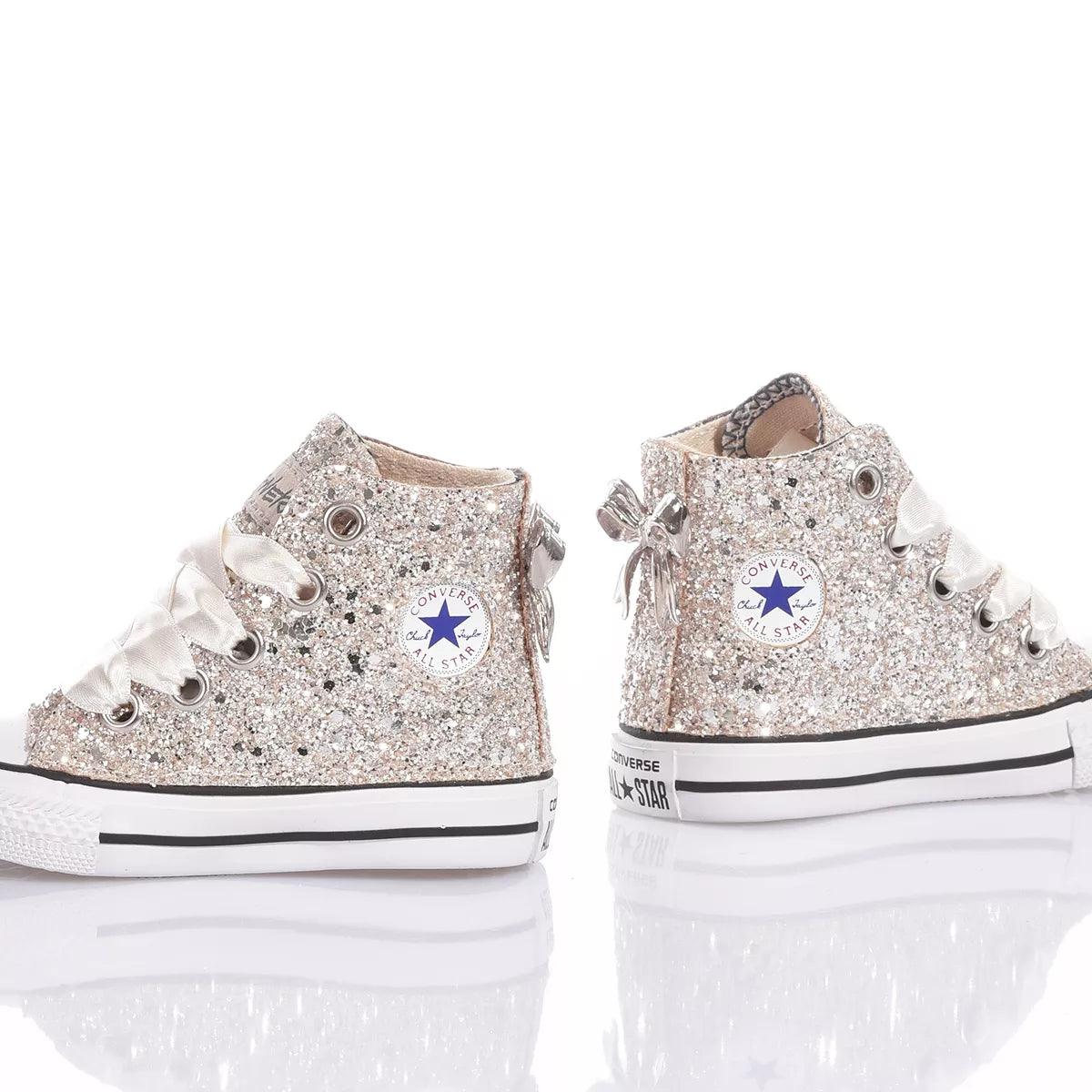 Scarpe bambini glitterate argento premaman su sfondo bianco, ideali per outfit premaman moda.
