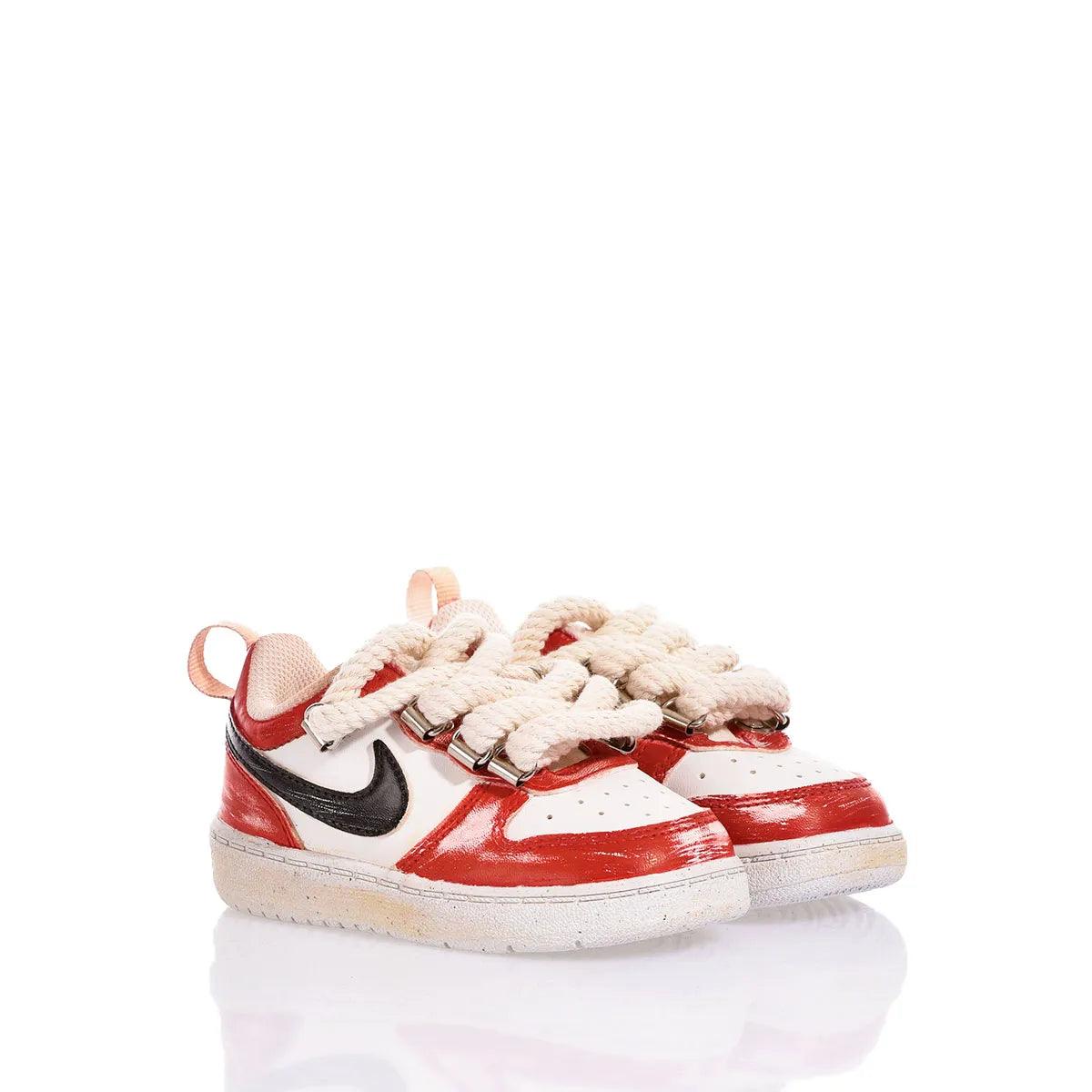 Scarpe sportive basse rosse e bianche con lacci spessi in corda, su fondo bianco.