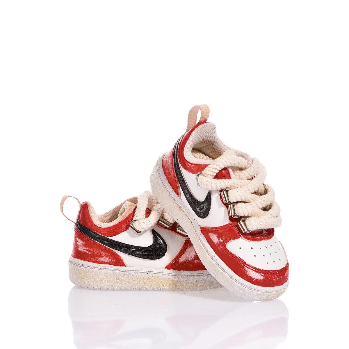 Scarpe neonato sportive bianche e rosse con lacci grossi su sfondo bianco