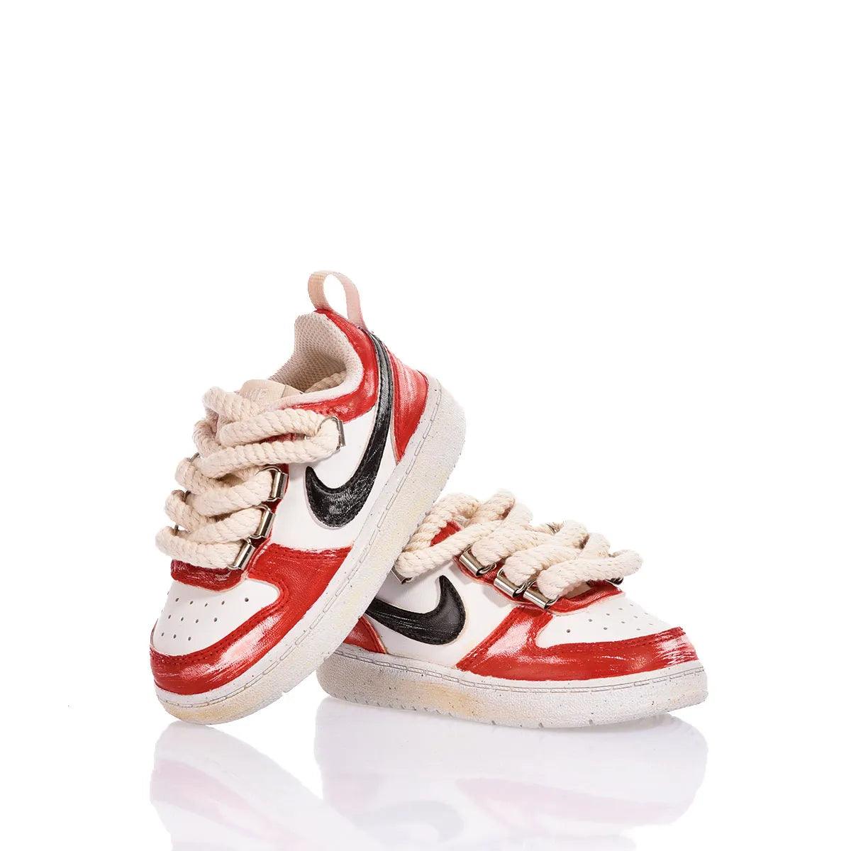 Scarpe da ginnastica bianche e rosse con lacci beige, fondo bianco riflettente.