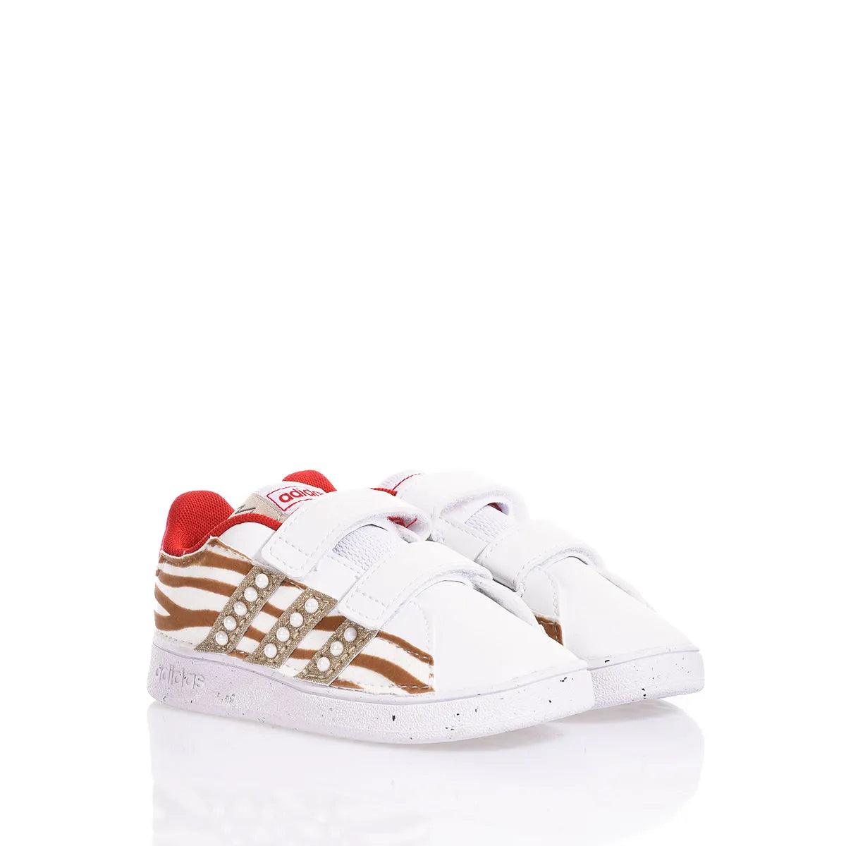 Scarpe bianche neonata con dettagli animalier, perfette per outfit premaman alla moda.