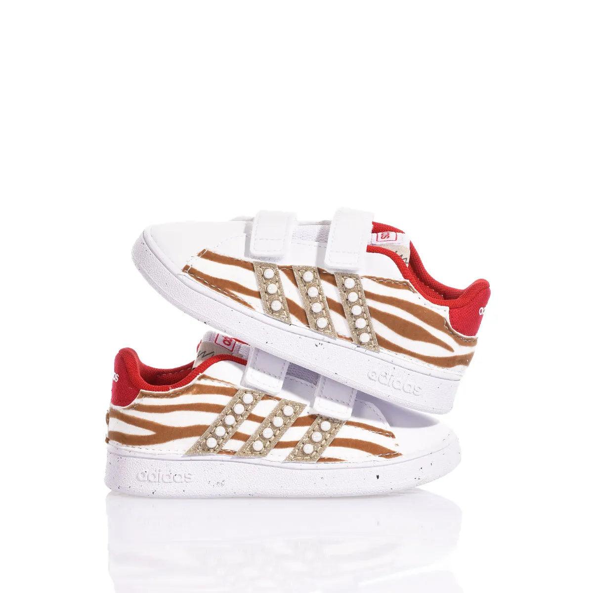 Scarpe sportive bianche a fantasia animalier con dettagli rossi, ideali per look premaman casual.