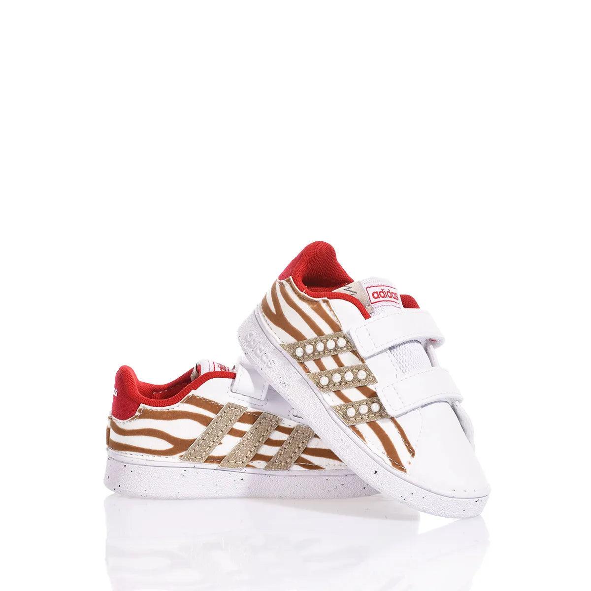 Scarpe sportive bianche con motivi zebrati marroni e dettagli oro, moda premaman trendy
