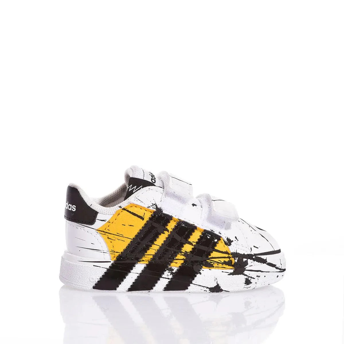 Scarpa sportiva bianca con dettagli neri e gialli, ideale per abbigliamento premaman casual.