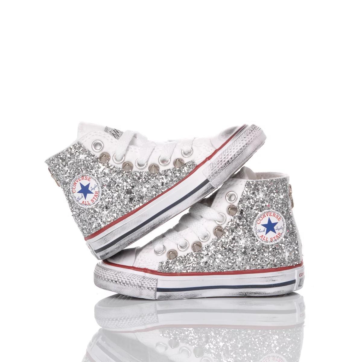 Sneakers glitterate argento comode per abbigliamento premaman, fondo bianco riflettente.