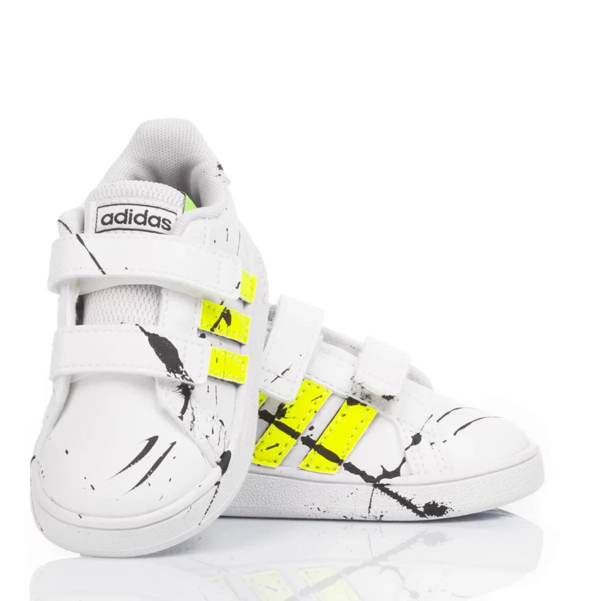 Scarpe sportive bianche da bambino con strisce gialle e dettagli neri, chiusura a strappo.