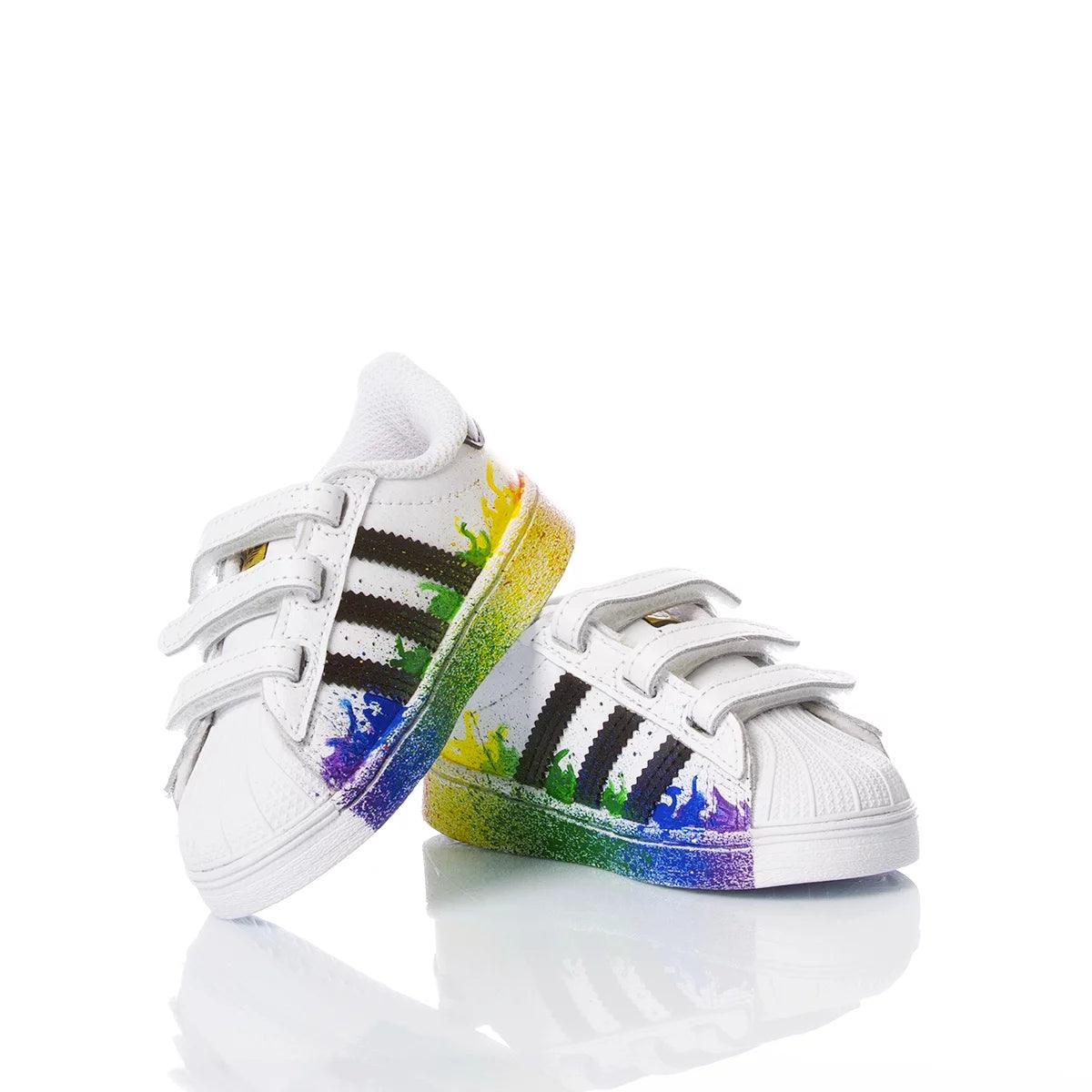 Sneakers bimbo bianche con chiusura a strappo e dettagli colorati arcobaleno, ideali per outfit premaman e abbigliamento premaman bambino.