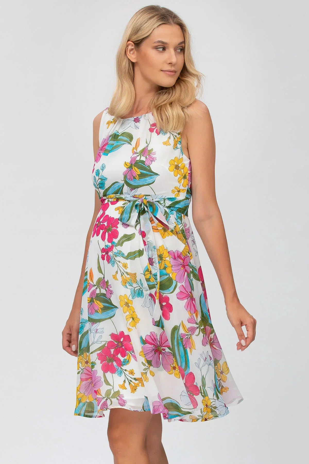 Abito premaman corto in chiffon bianco con stampa floreale colorata e cintura in vita.