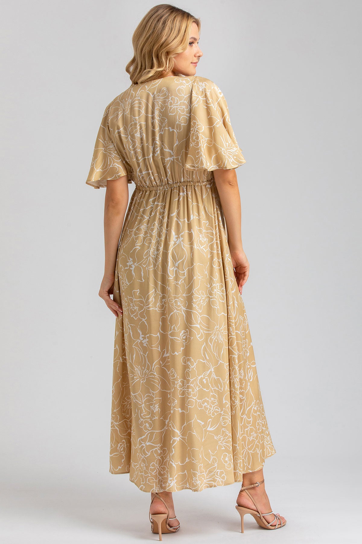 Abito premaman lungo beige con stampa floreale bianca, maniche corte, visto da dietro.