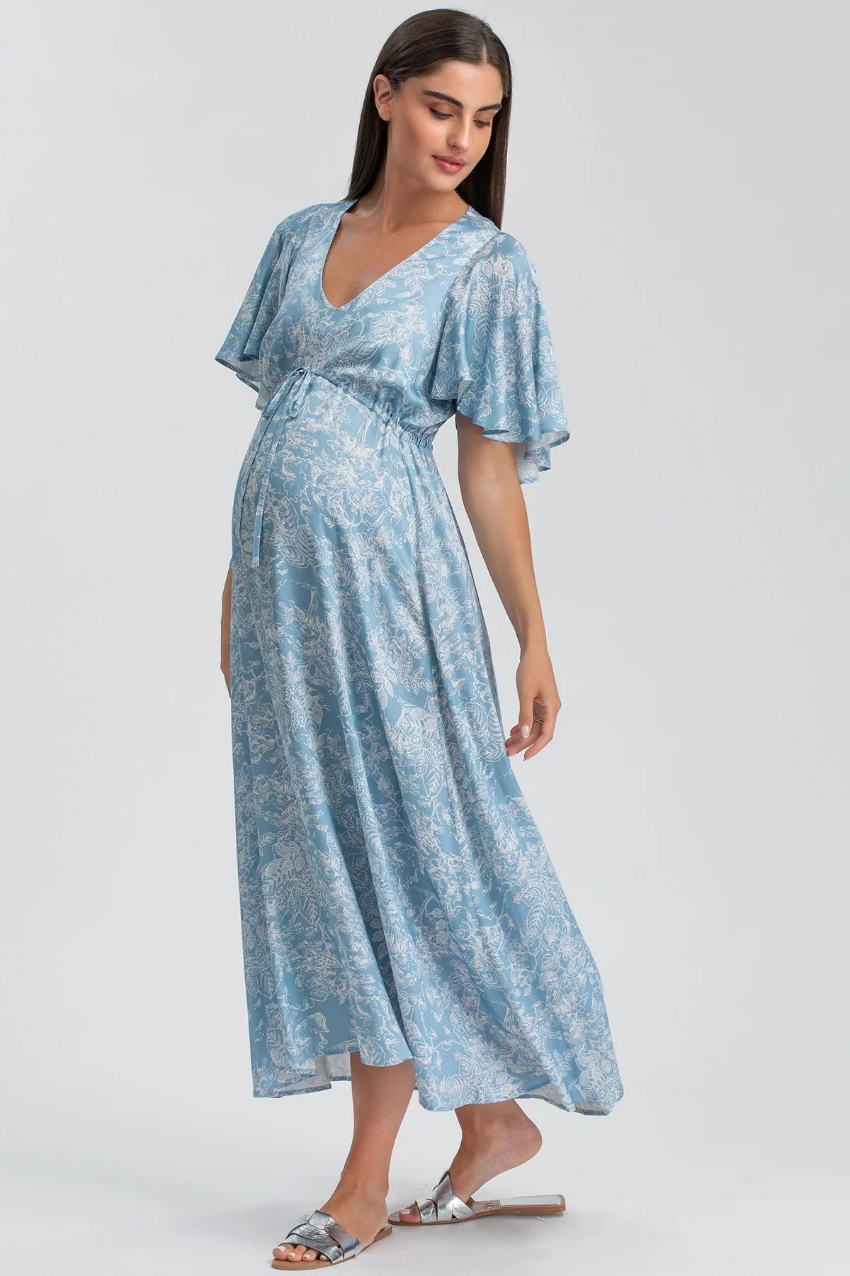 Abito premaman elegante azzurro con fantasia floreale, maniche corte e scollo a V.