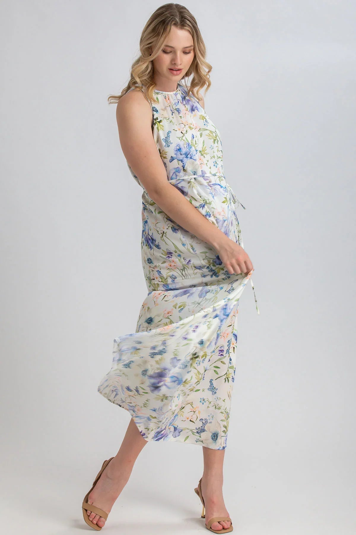 Donna incinta con abito premaman lungo floreale smanicato, tessuto leggero elegante.