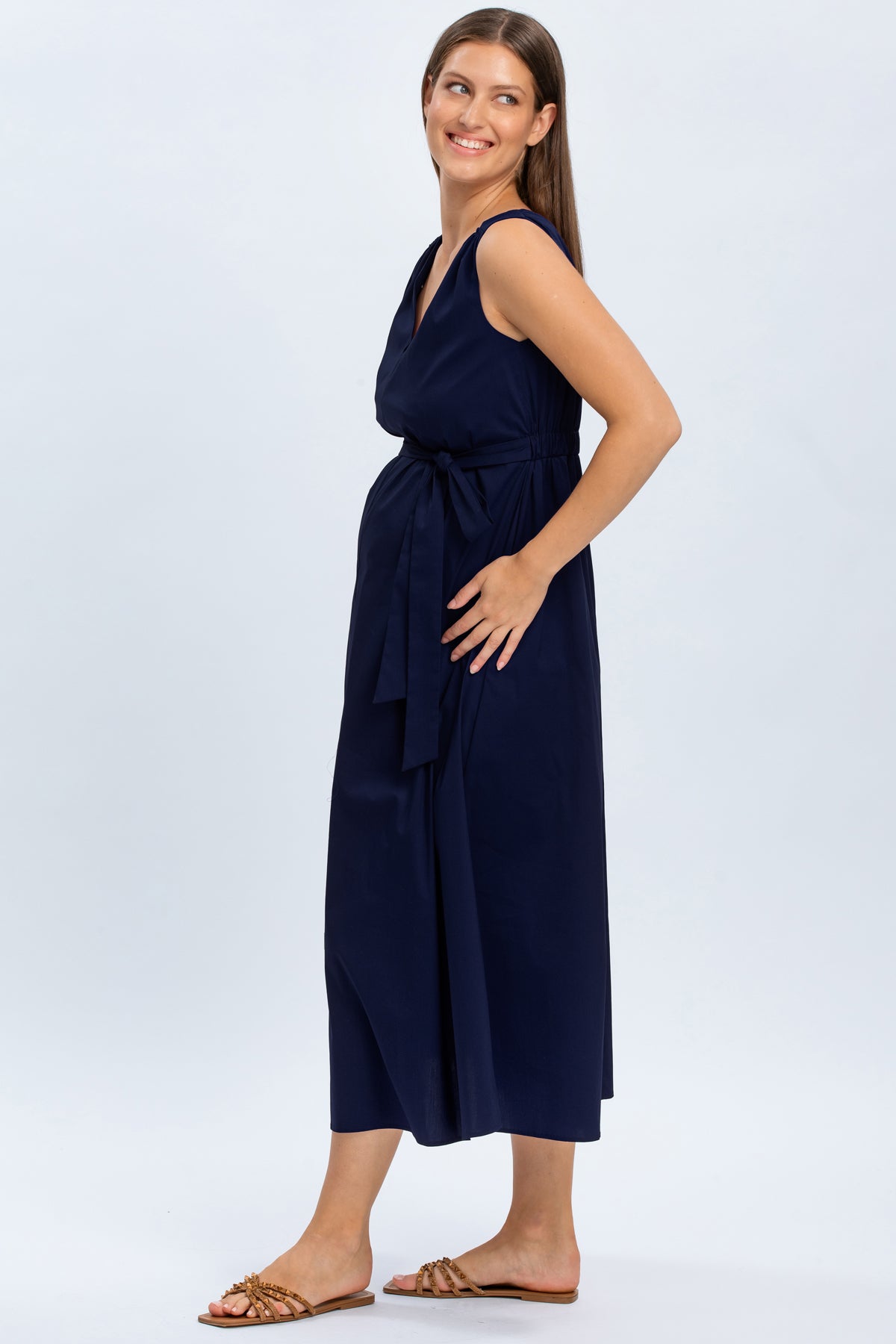 Abito premaman elegante blu senza maniche, con cintura in vita, indossato da donna sorridente