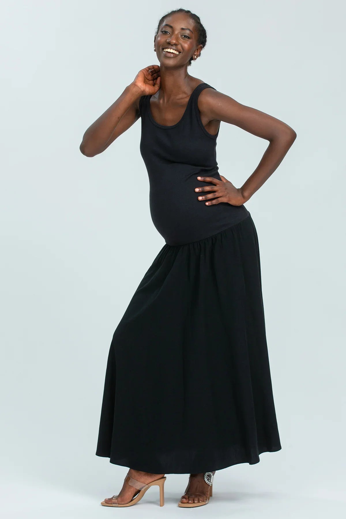 Abito premaman nero lungo elegante, perfetto per la gravidanza, indossato da una donna sorridente