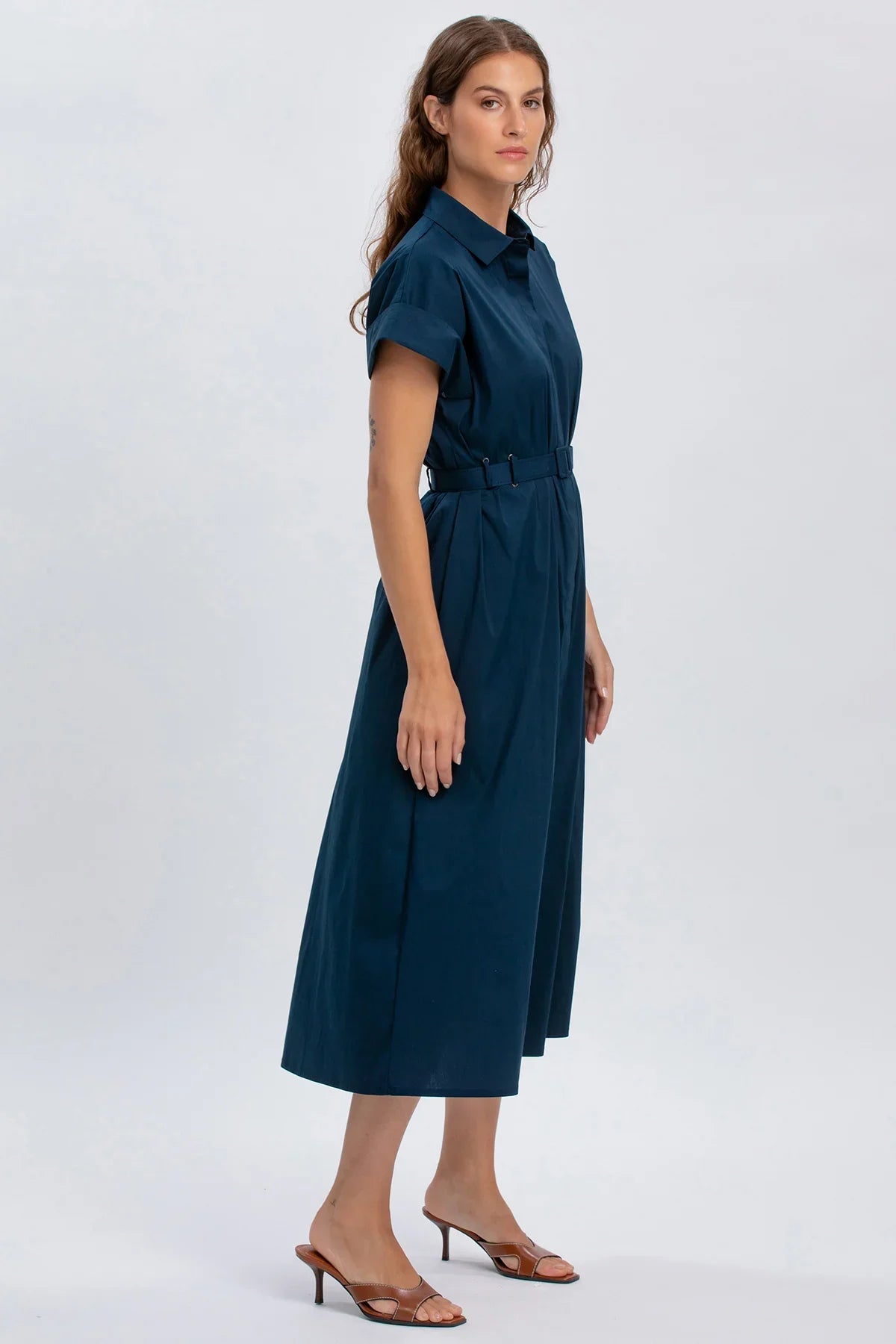 Abito premaman blu elegante con cintura, maniche corte e gonna midi, su sfondo chiaro.