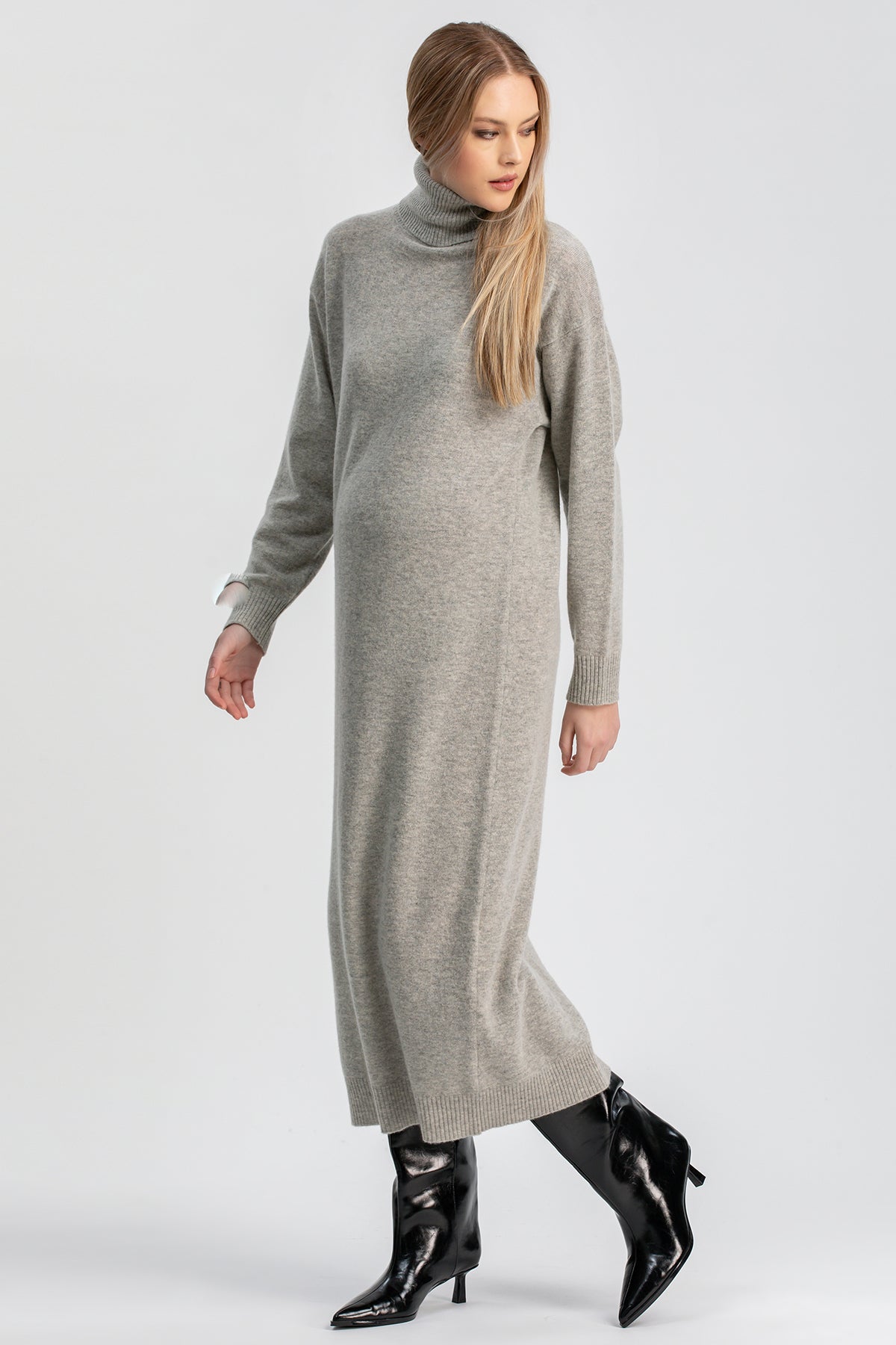 Abito premaman in maglia grigia comodo lungo, indossato con stivali neri