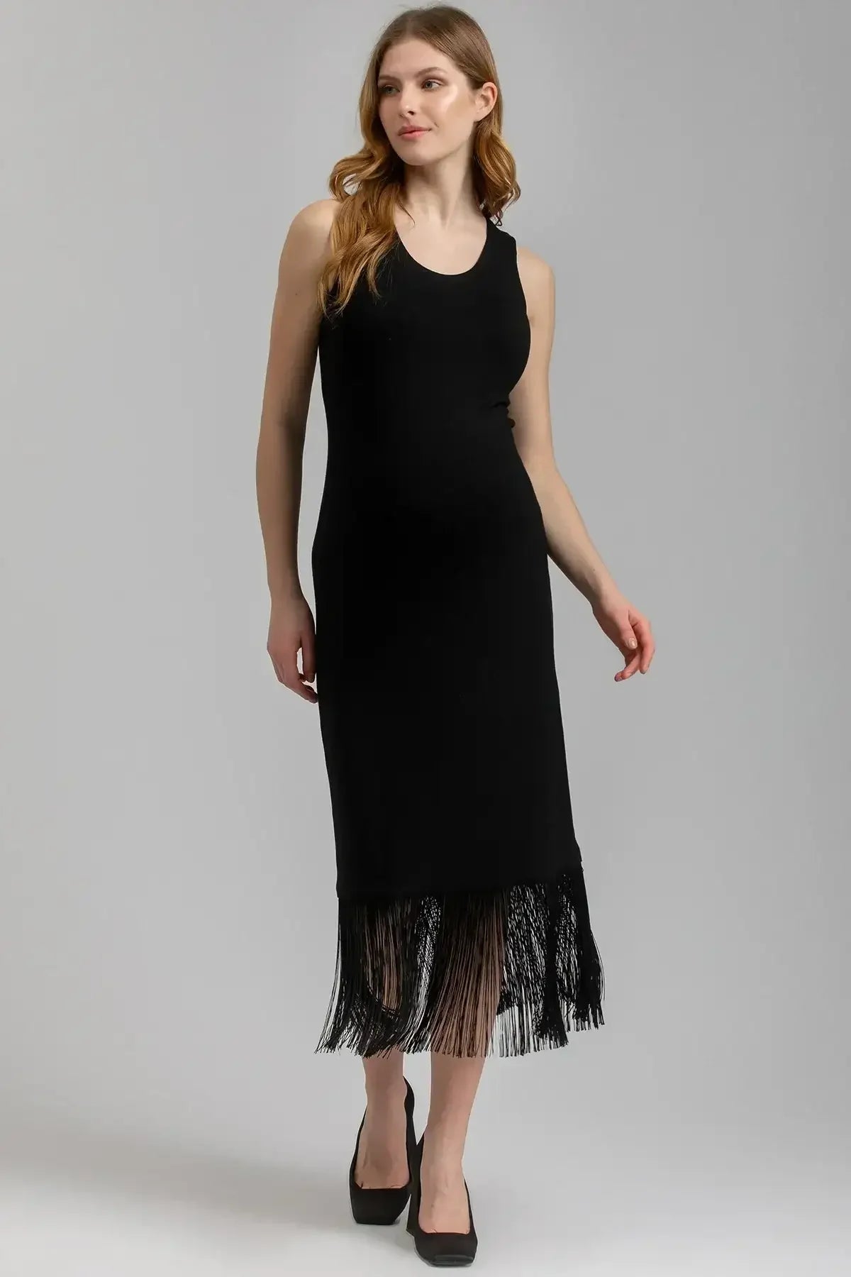Abito premaman nero smanicato con frange eleganti sull'orlo, modello donna incinta.