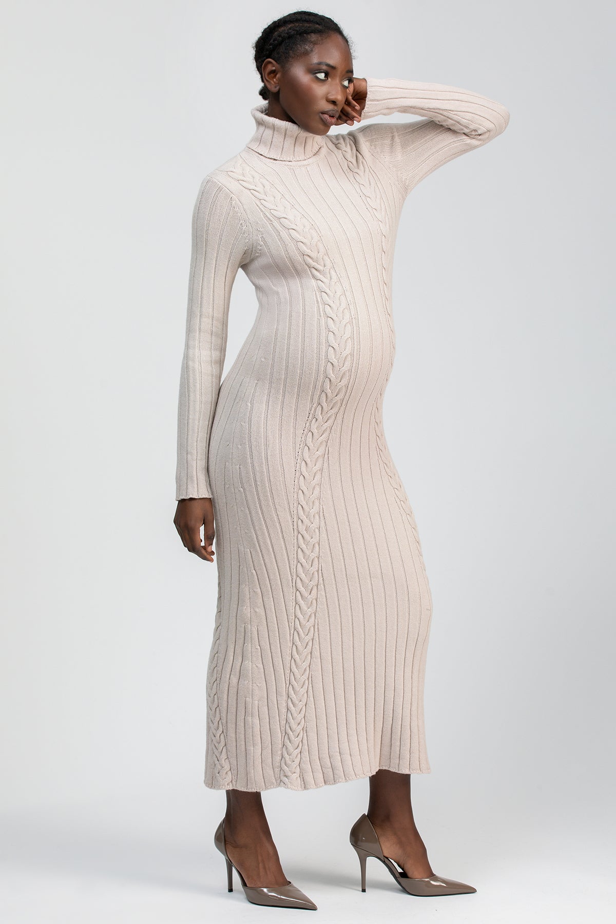 Abito premaman in maglia beige con lavorazione treccia, collo alto e maniche lunghe.