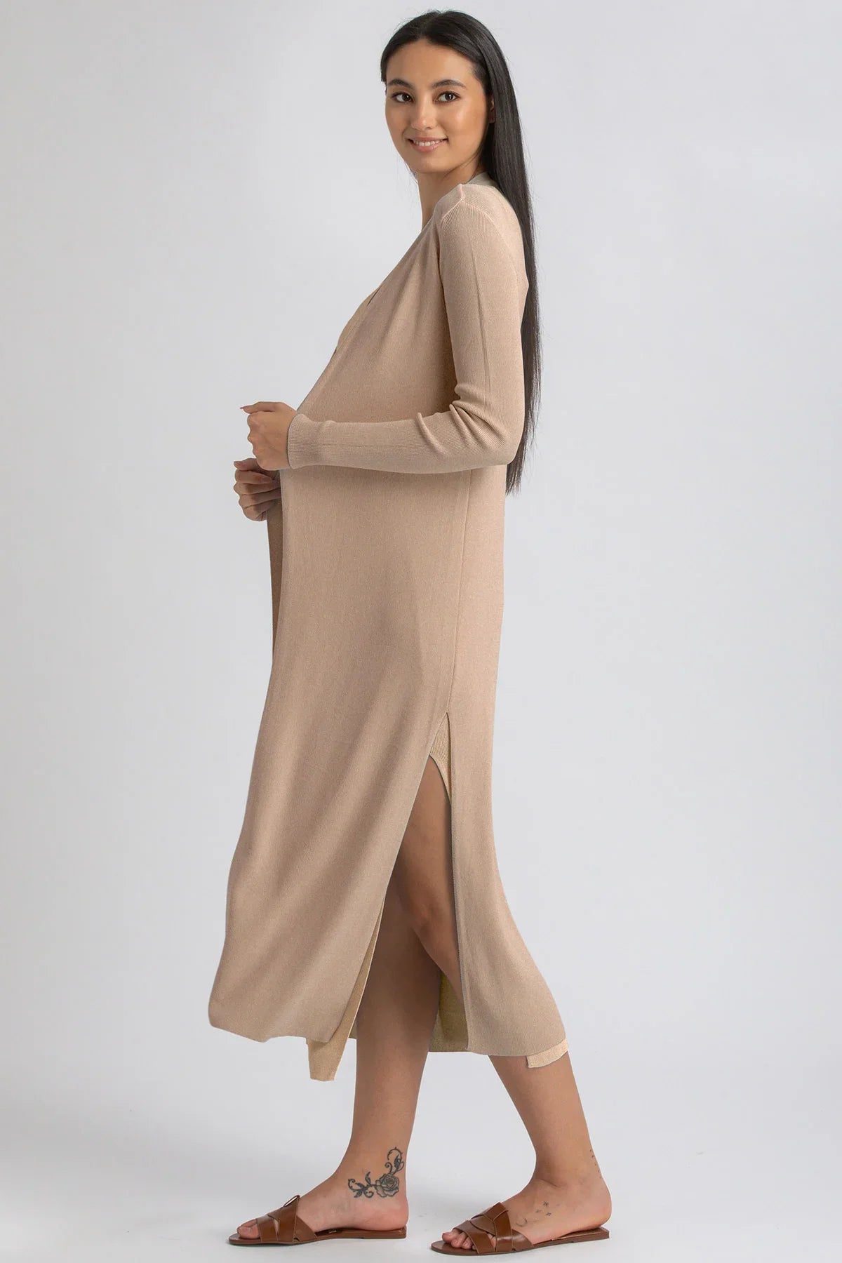 Donna incinta con abito premaman beige a maniche lunghe e spacco laterale