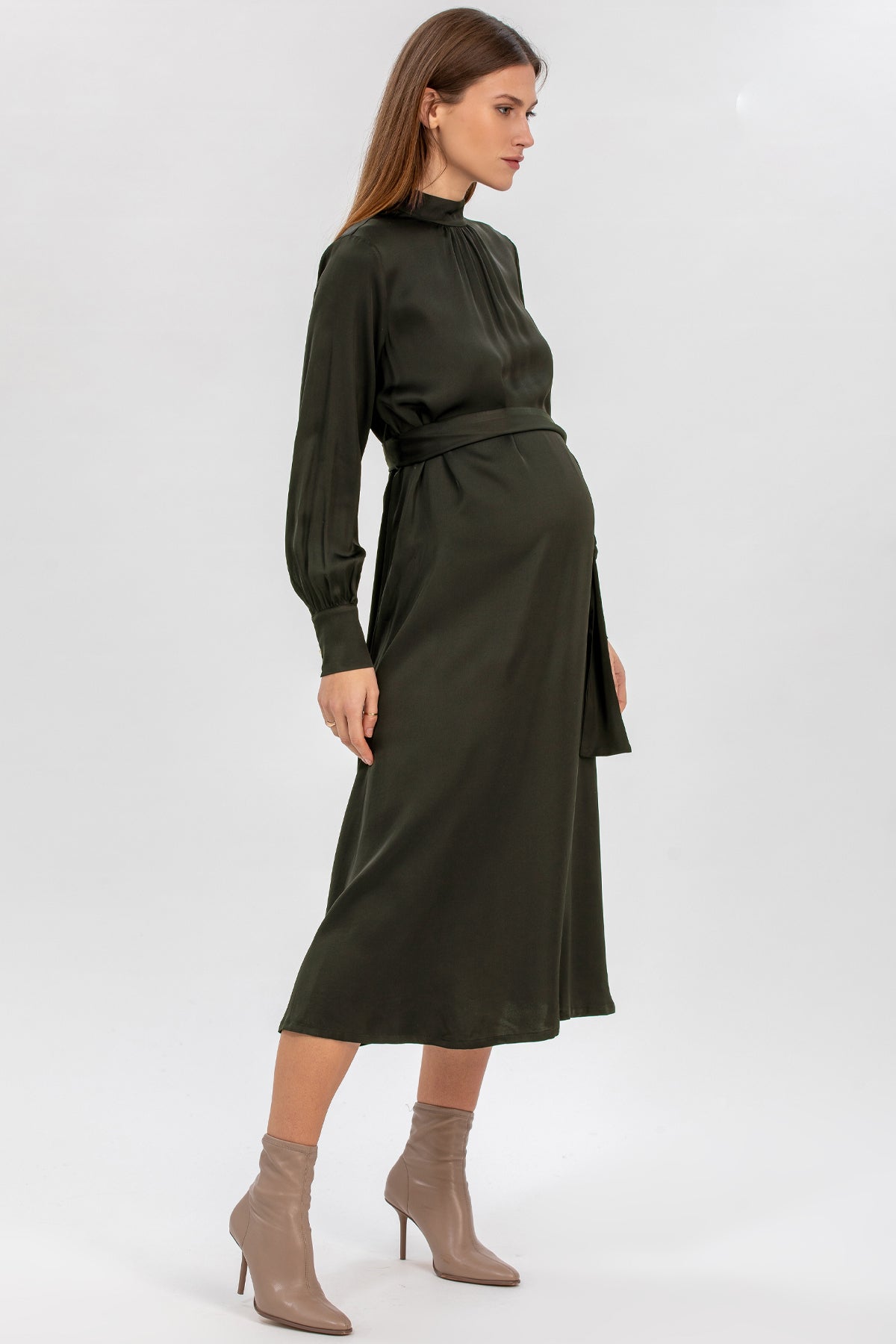 Donna incinta indossa abito premaman elegante verde scuro a maniche lunghe