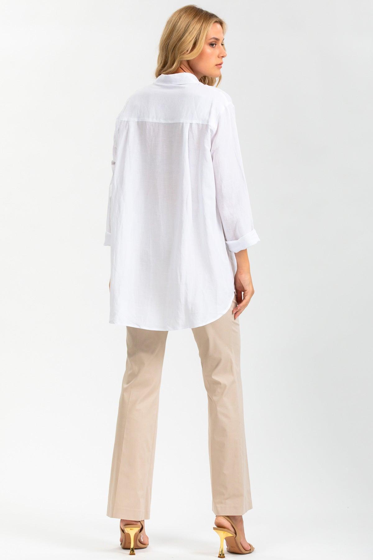 Donna con camicia premaman bianca oversize, pantaloni beige e sandali con tacco, vista posteriore