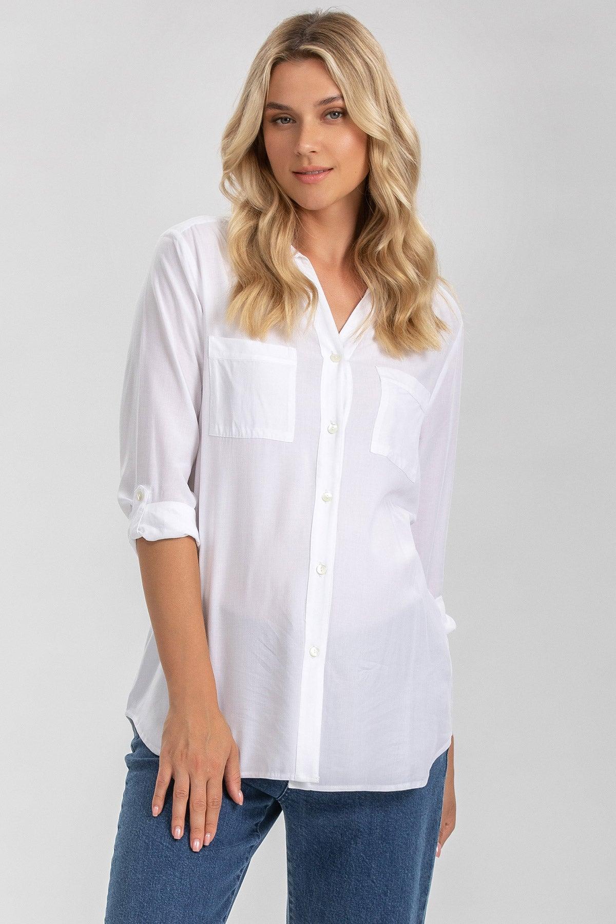 Camicia premaman bianca a maniche lunghe, tessuto leggero, indossata da donna in jeans