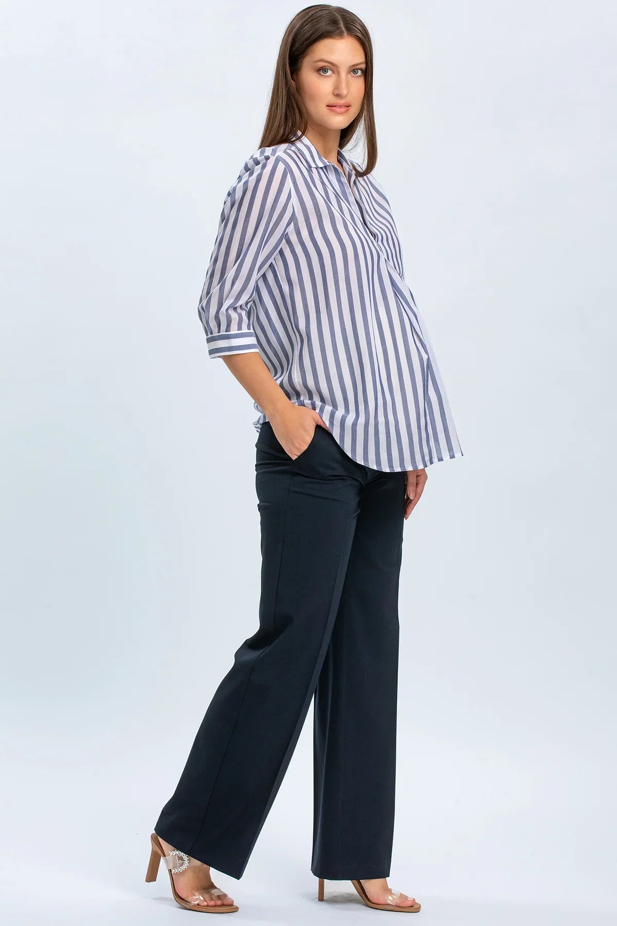 Modella indossa camicia premaman a righe con pantaloni eleganti premaman blu scuro