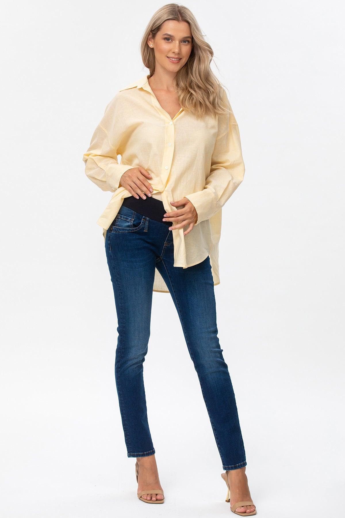 Modella in camicia beige premaman e jeans elasticizzati, abbigliamento gravidanza elegante