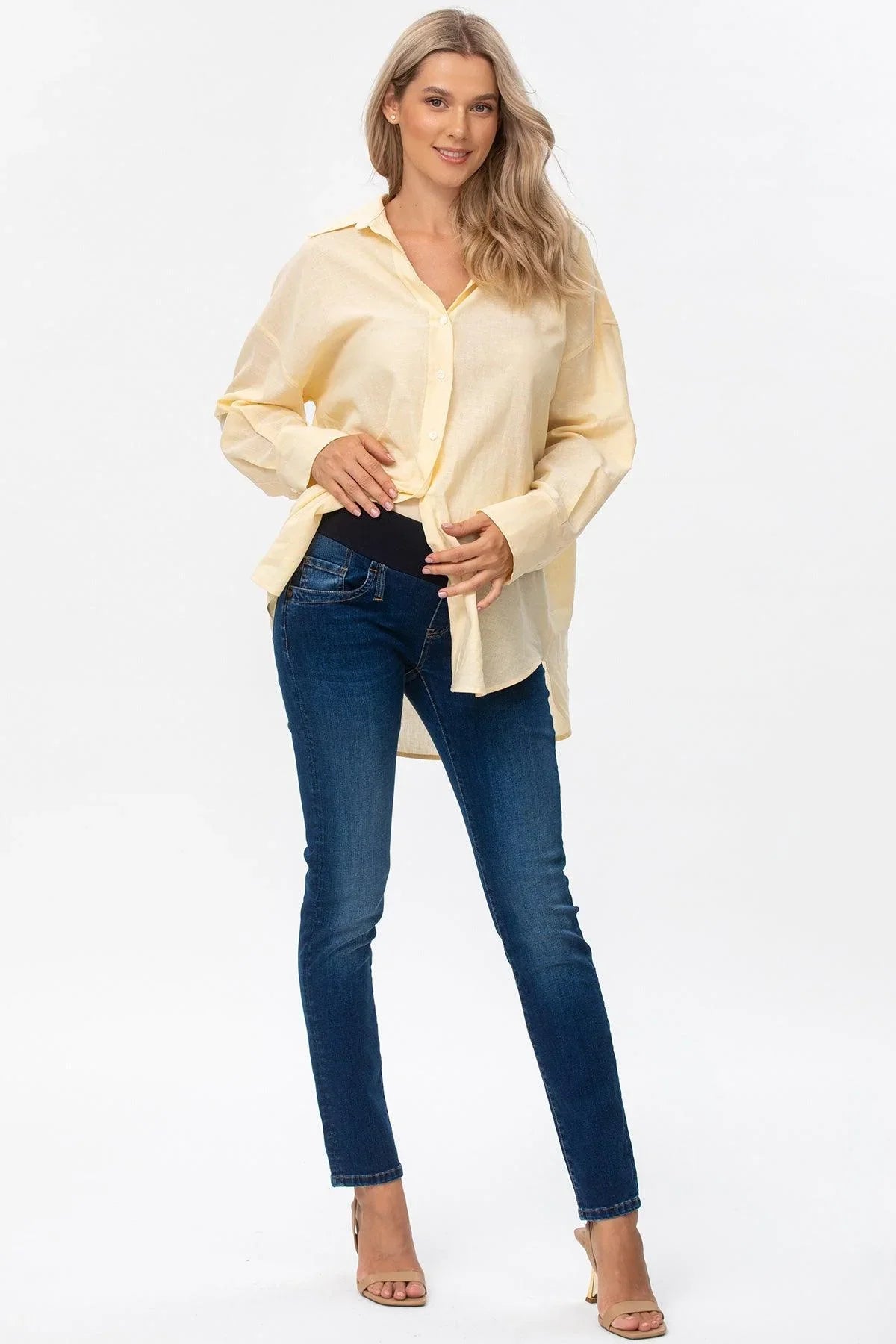 Modella in camicia beige premaman e jeans elasticizzati, abbigliamento gravidanza elegante