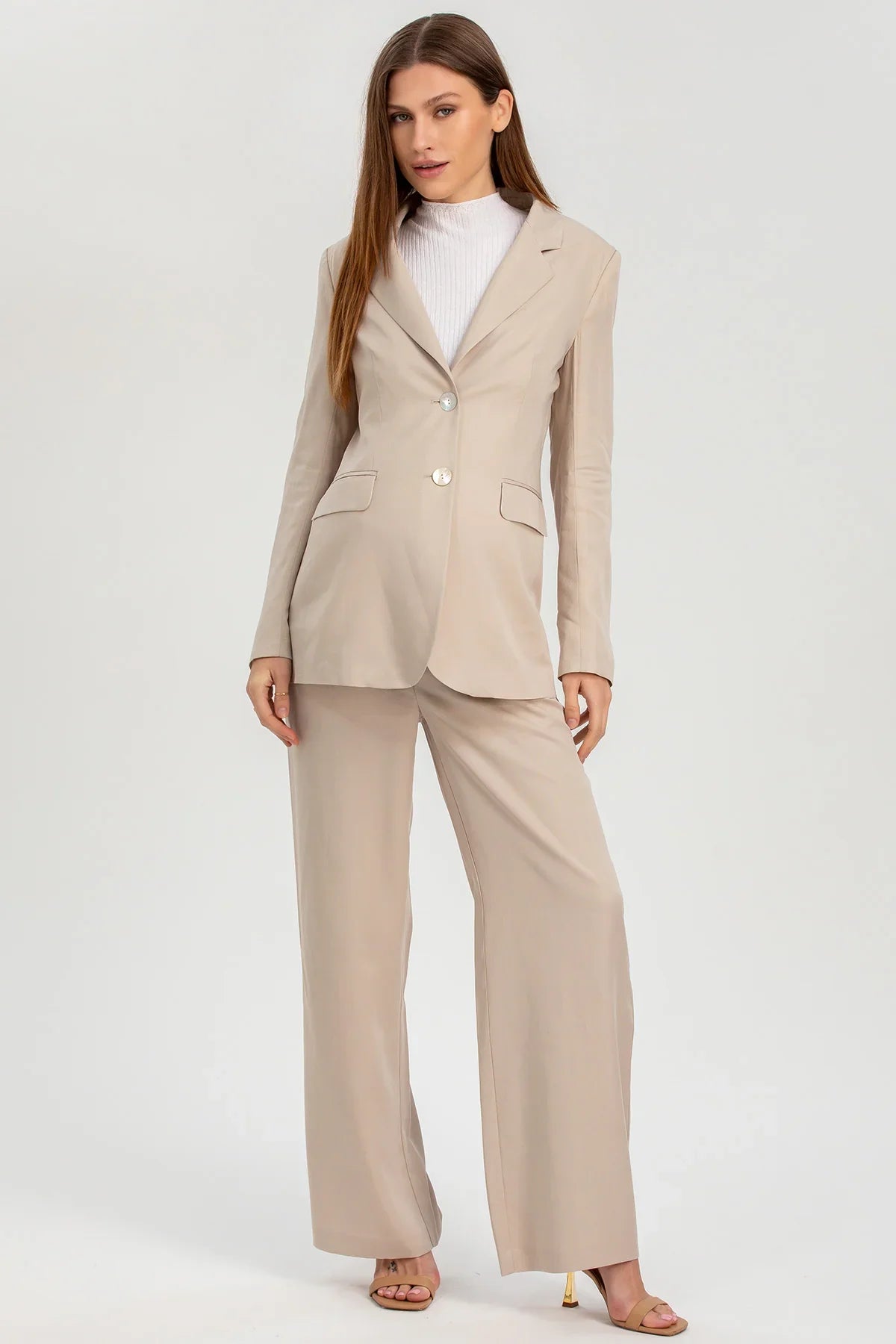Completo premaman elegante beige con giacca e pantaloni larghi, moda maternità.