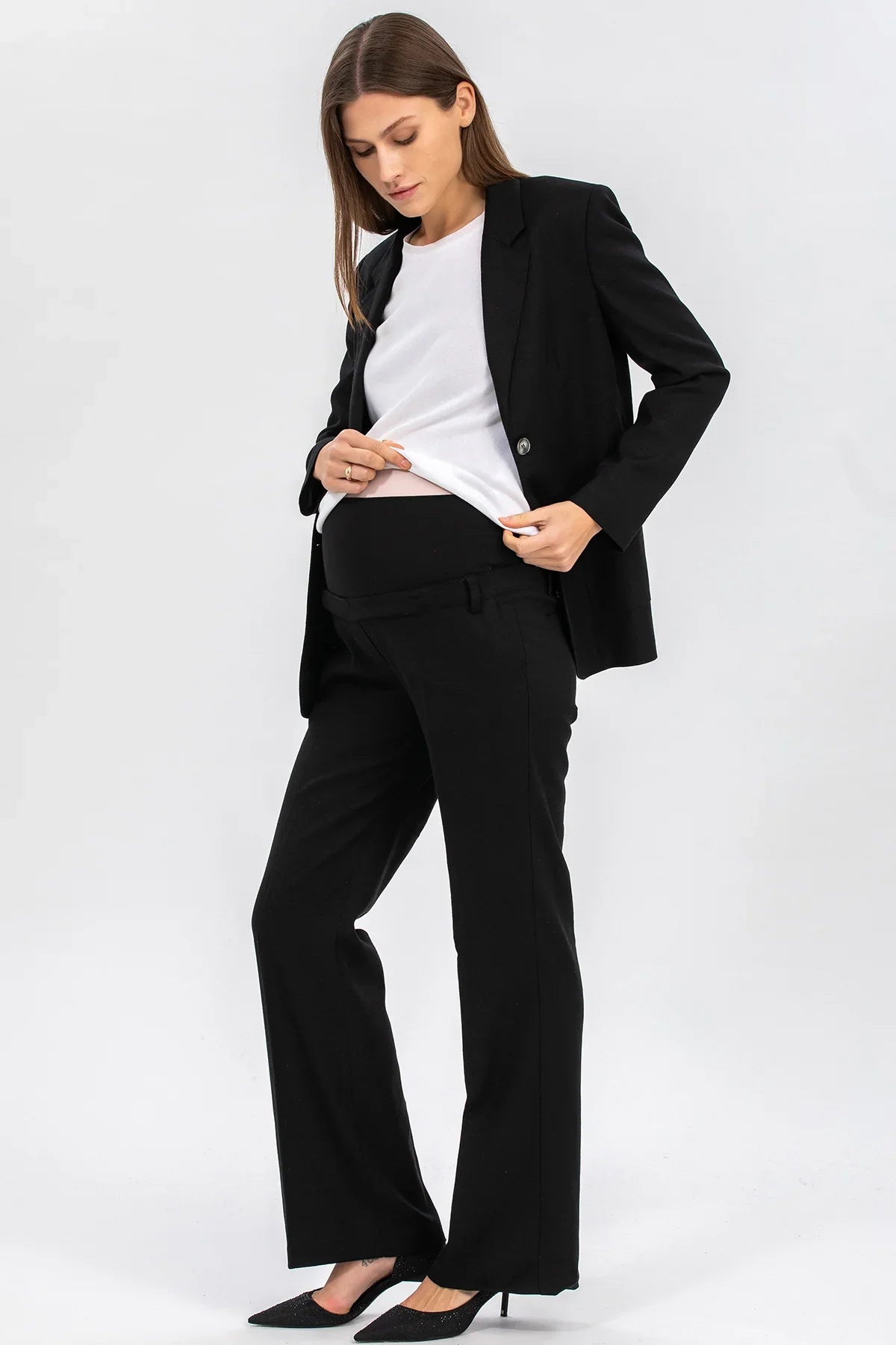 Donna premaman con completo elegante nero e top bianco, abbigliamento gravidanza