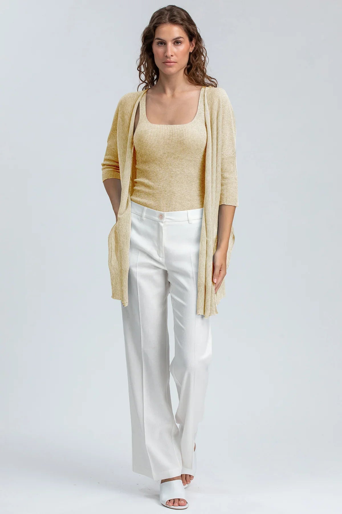 Abbigliamento premaman elegante: cardigan beige e pantaloni bianchi ampi per maternità