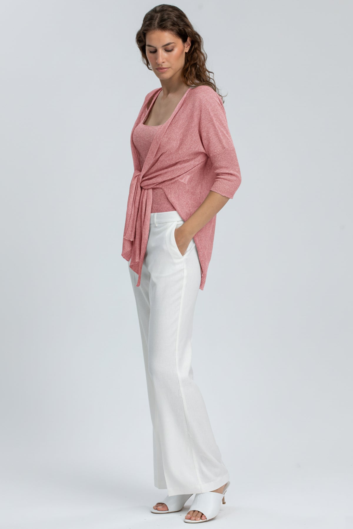 Outfit premaman elegante con cardigan rosa, top coordinato e pantaloni bianchi larghi