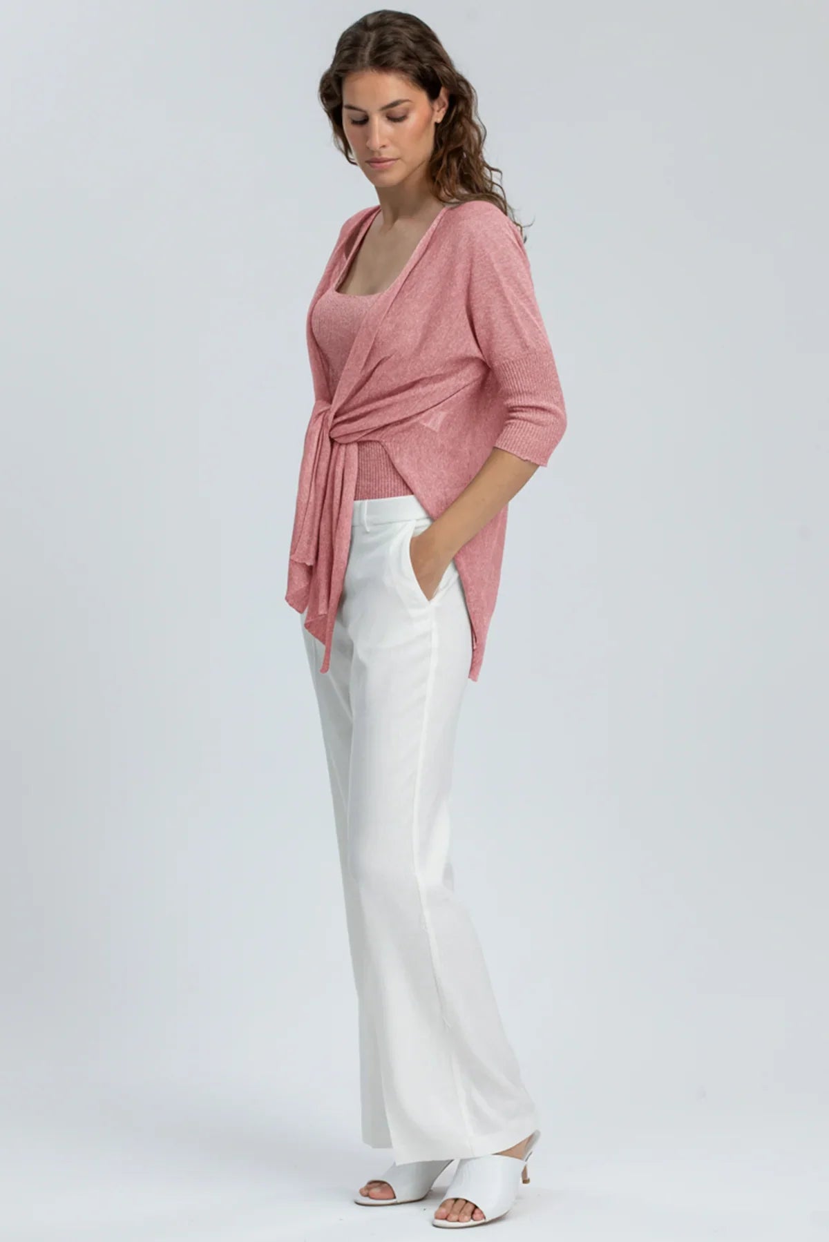 Outfit premaman elegante con cardigan rosa, top coordinato e pantaloni bianchi larghi