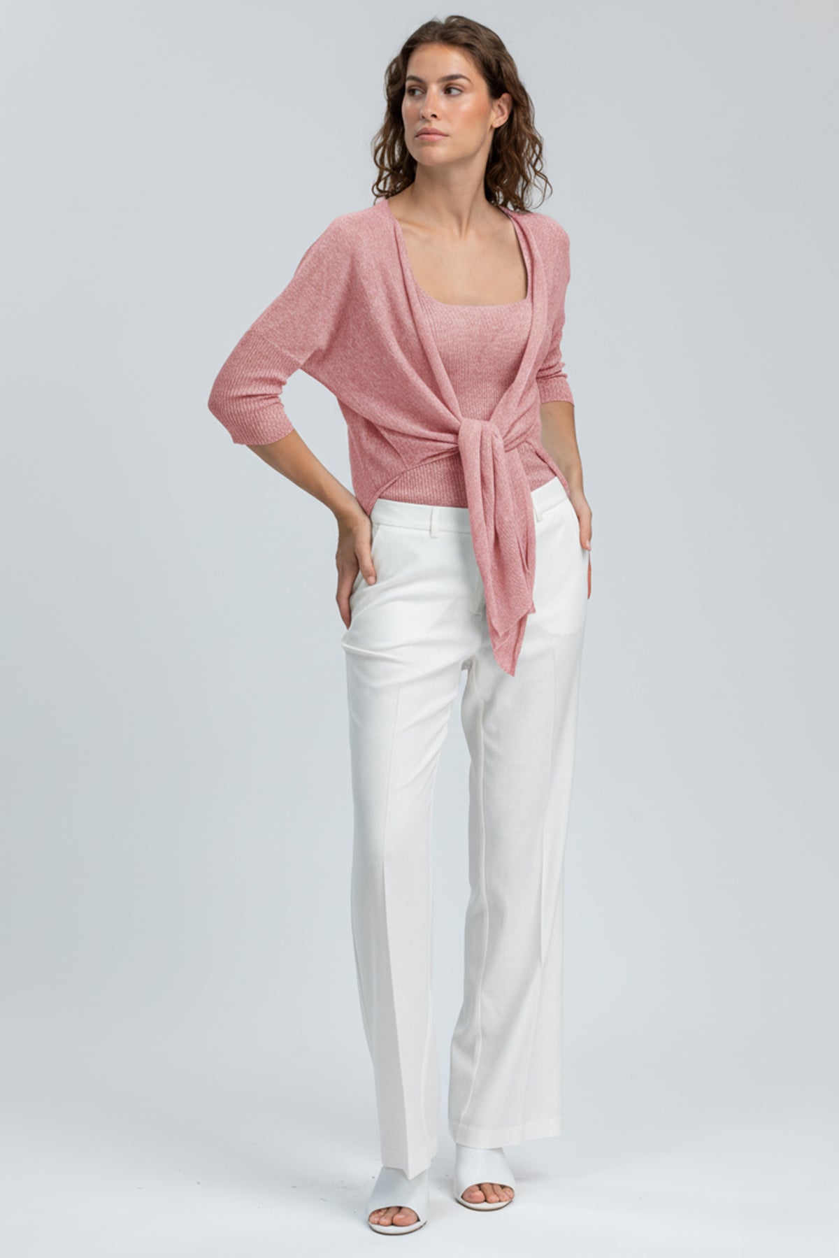 Completo premaman elegante con maglia rosa intrecciata e pantaloni bianchi larghi