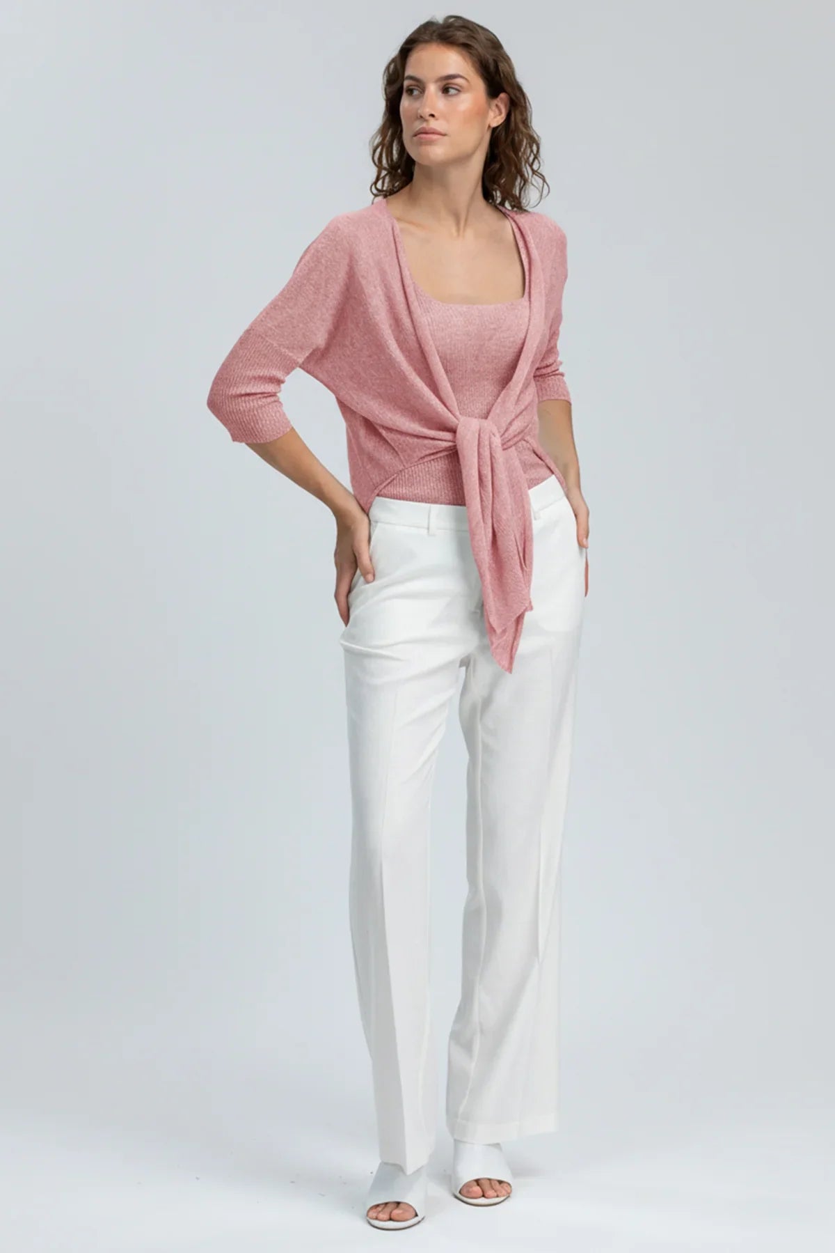 Completo premaman elegante con maglia rosa intrecciata e pantaloni bianchi larghi
