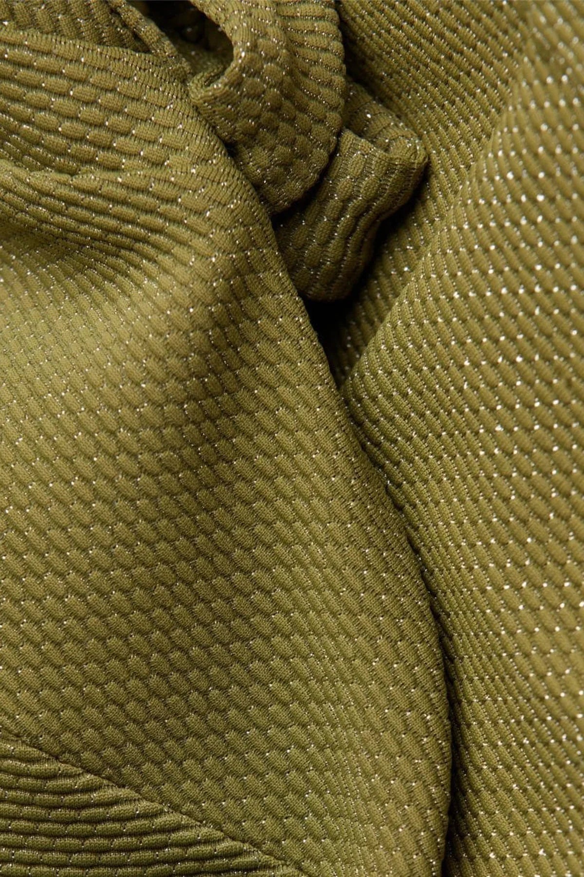 Dettaglio tessuto premaman verde oliva a trama strutturata con fili lucenti