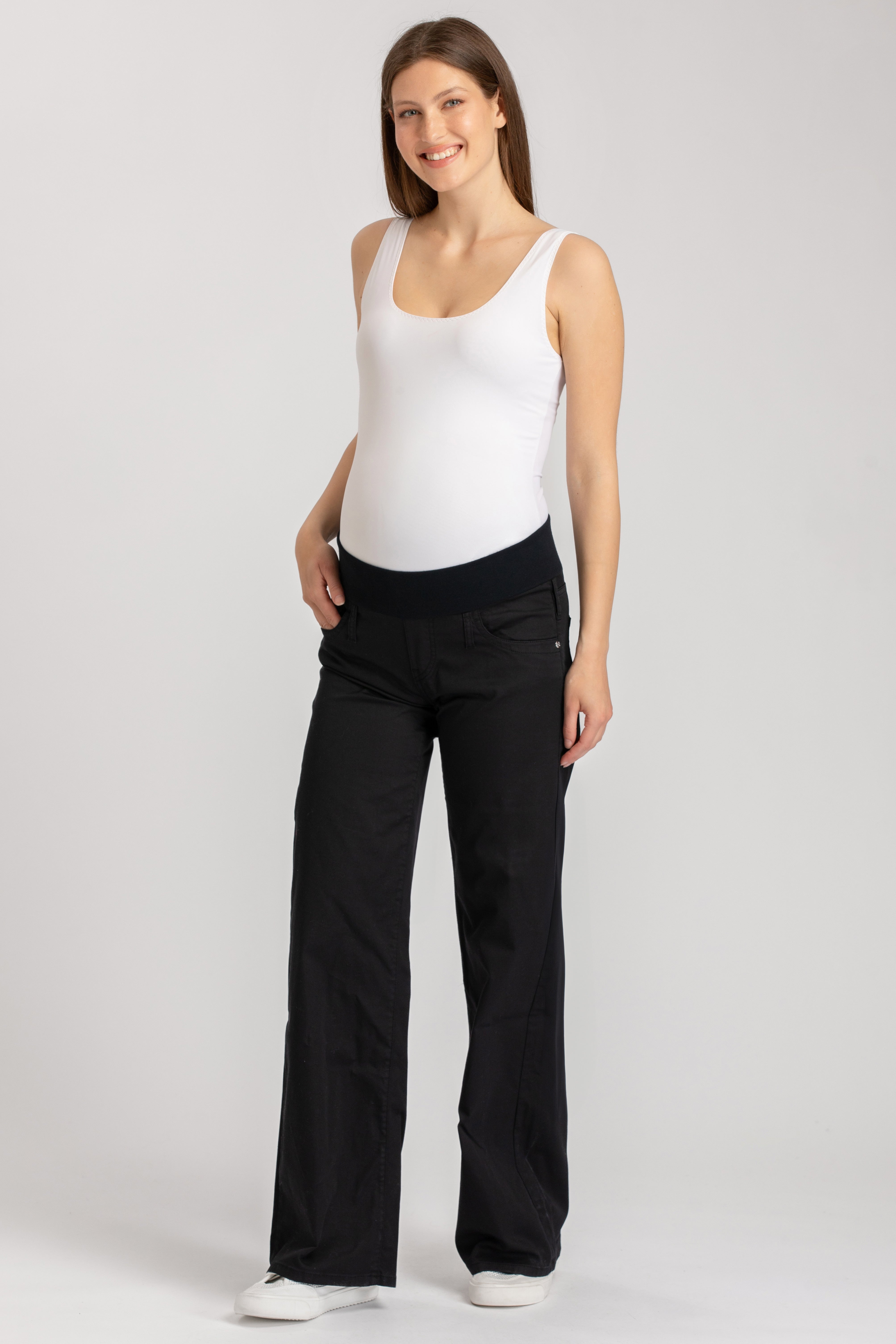 Pantaloni premaman neri a gamba larga con fascia elastica, indossati da donna incinta