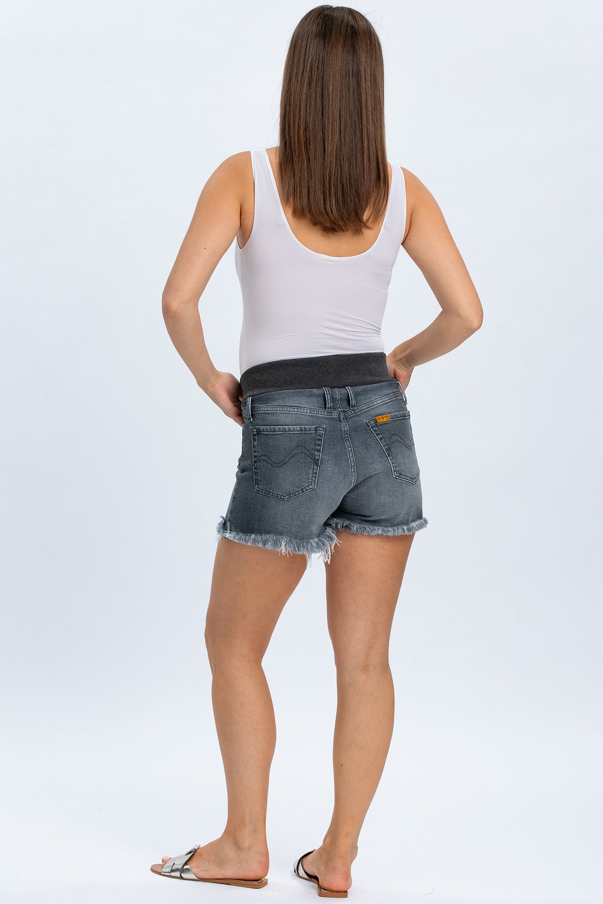 Shorts premaman in denim grigio con fascia elastica e bordo sfrangiato indossati da donna