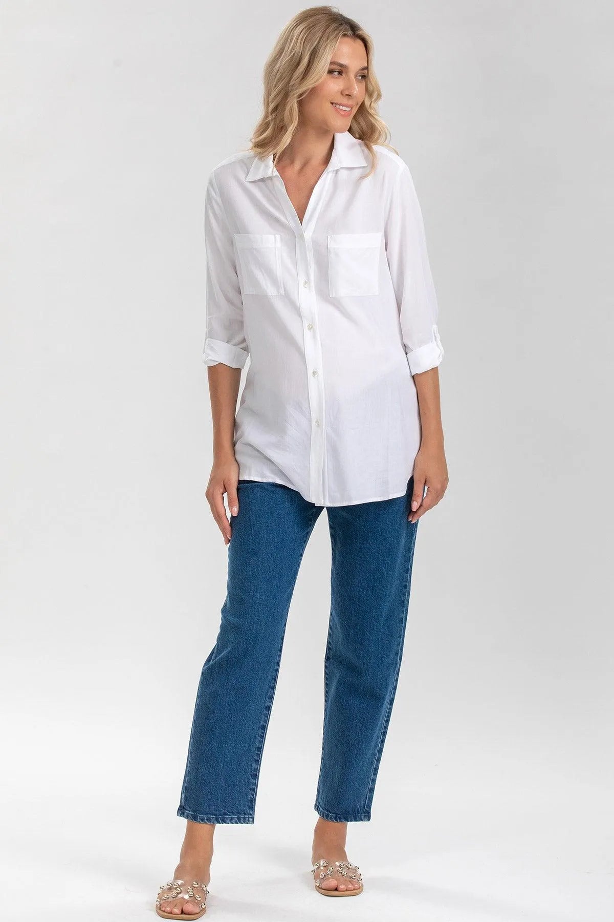 Donna incinta in camicia bianca premaman e jeans, look casual elegante gravidanza