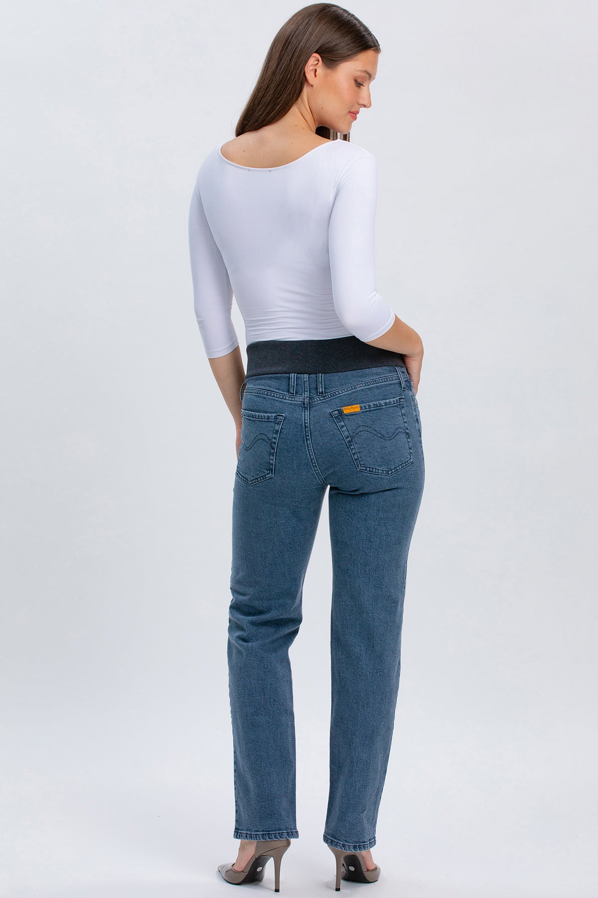 Modella indossa jeans premaman grigi a gamba dritta con fascia elastica nera.