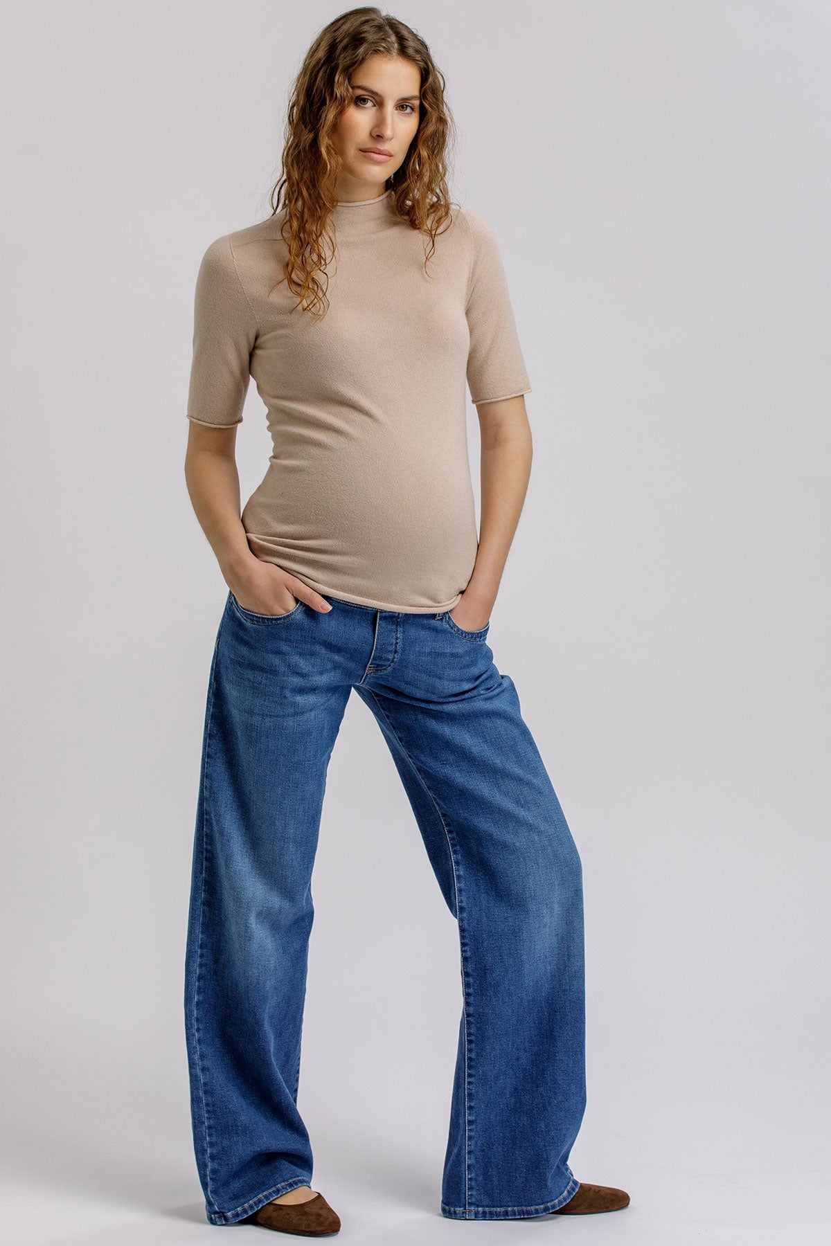 Beige maternity knit top with high neck.