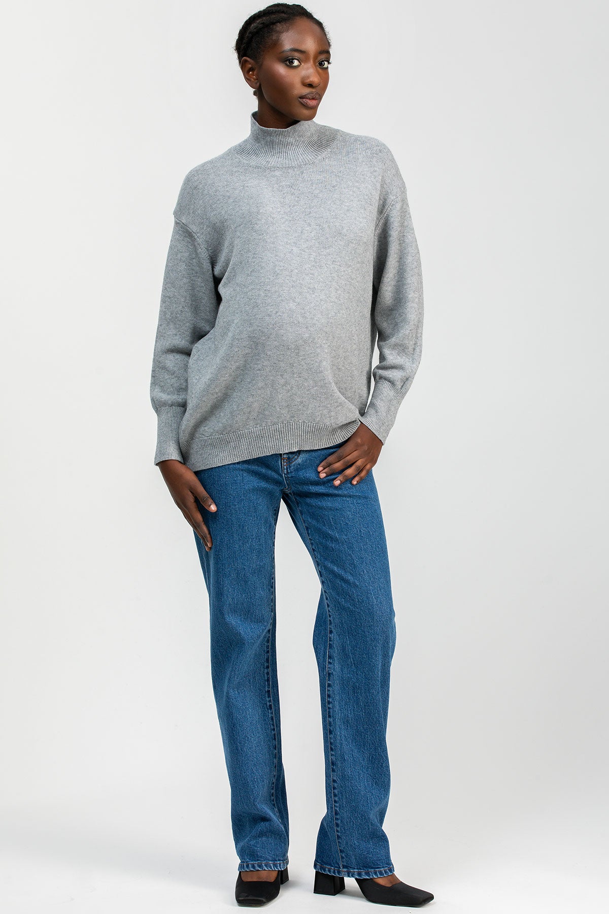 Modella indossa jeans premaman dritti a vita alta con fascia elastica comoda, abbigliamento premaman elegante.