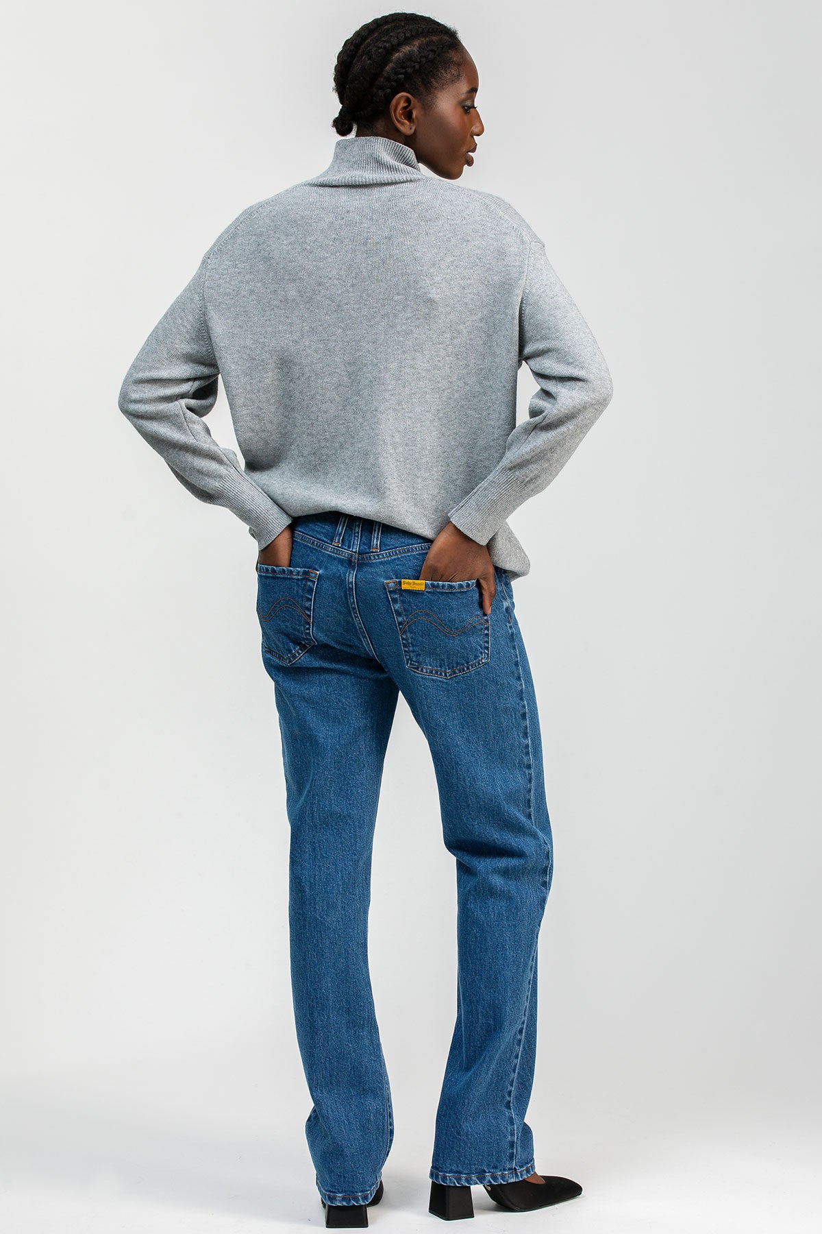 Model wearing high-waisted straight-leg maternity jeans with a comfortable stretchy belly band, styled for an elegant maternity look.