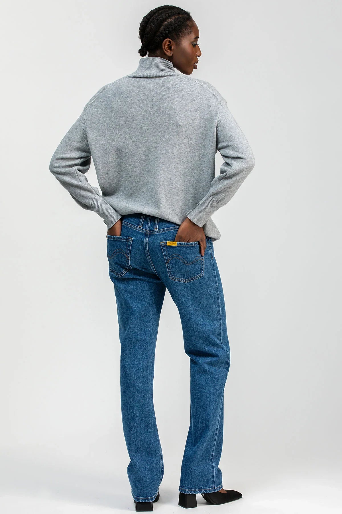 Model wearing high-waisted straight-leg maternity jeans with a comfortable stretchy belly band, styled for an elegant maternity look.